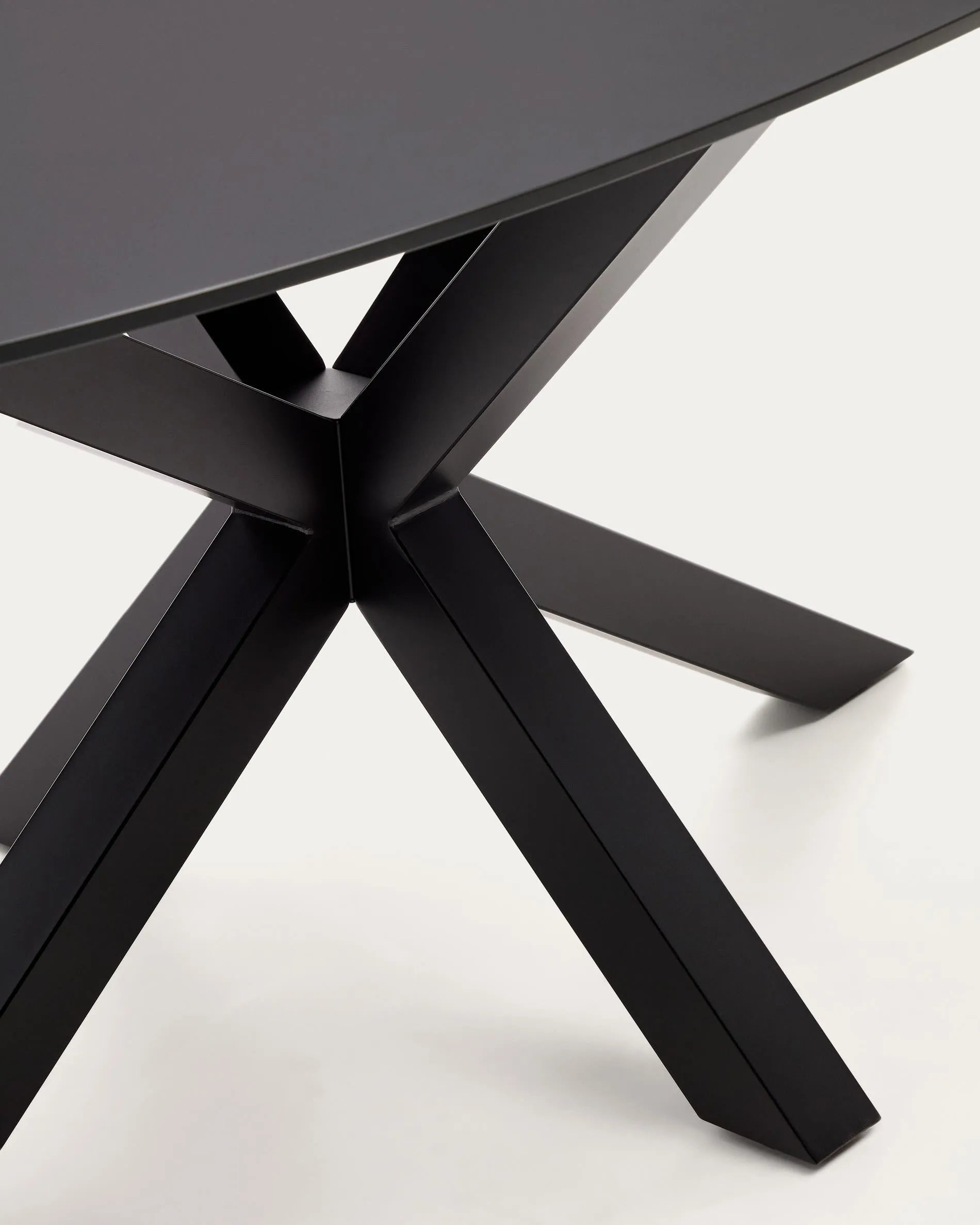 Eleganter Argo Tisch: Transparentes Glas trifft auf schwarze Stahlbeine, ideal für stilvolle Zusammenkünfte.
