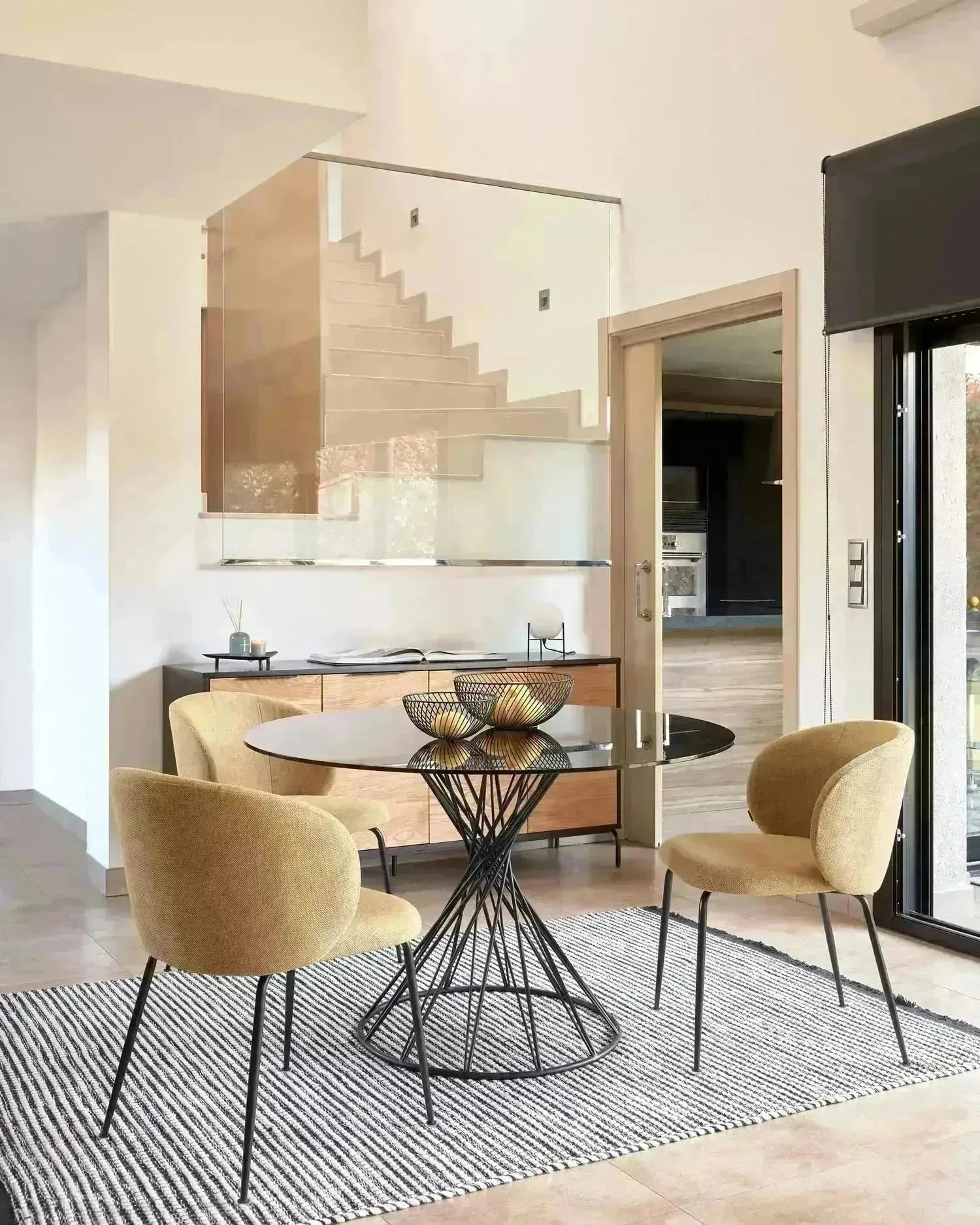 Eleganter runder Tisch mit Glasplatte und schwarzen Stahlbeinen, Ø 120 cm, perfekt für moderne Wohnräume, von Kave Home.