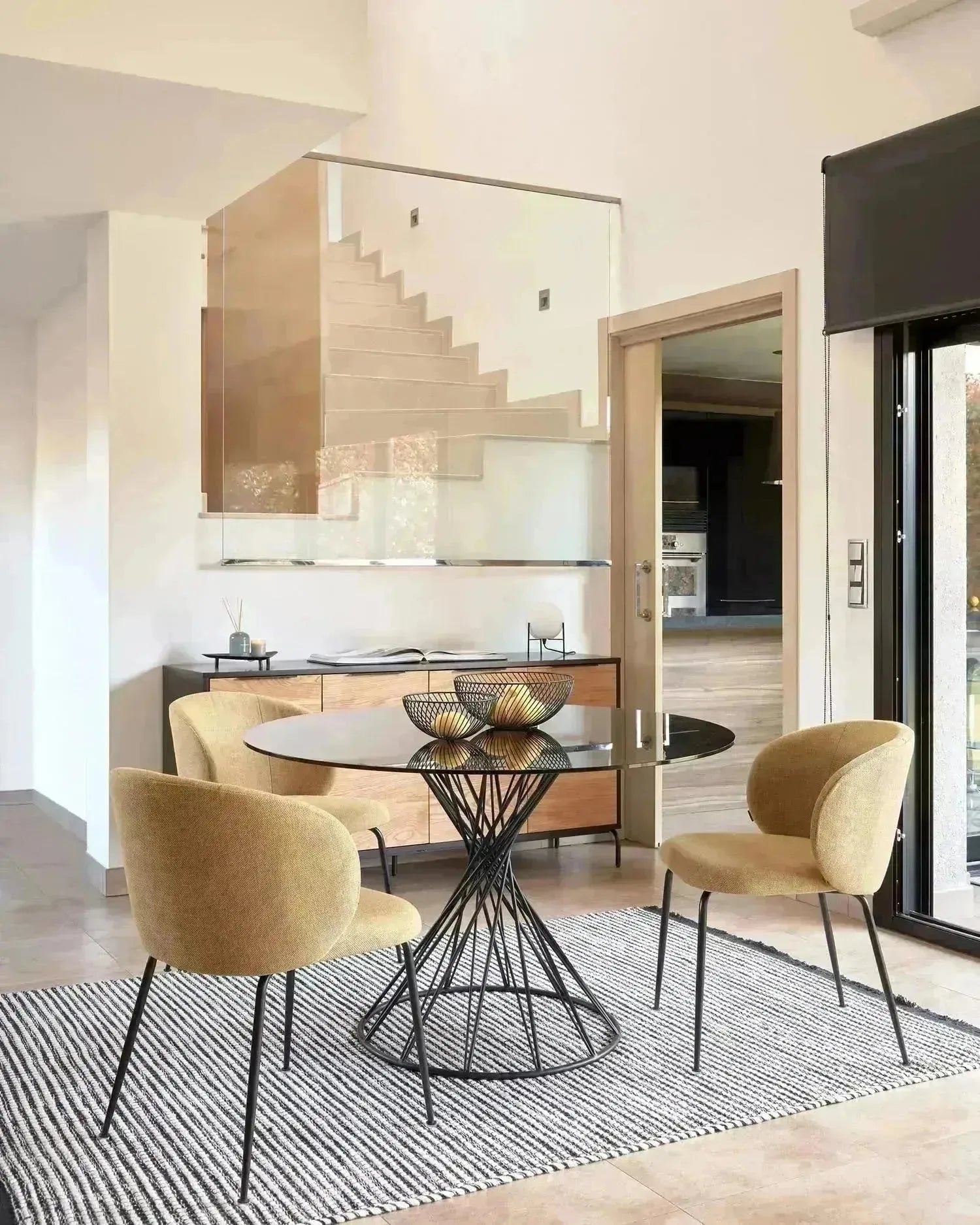 Eleganter runder Tisch mit Glasplatte und schwarzen Stahlbeinen, Ø 120 cm, perfekt für moderne Wohnräume, von Kave Home.