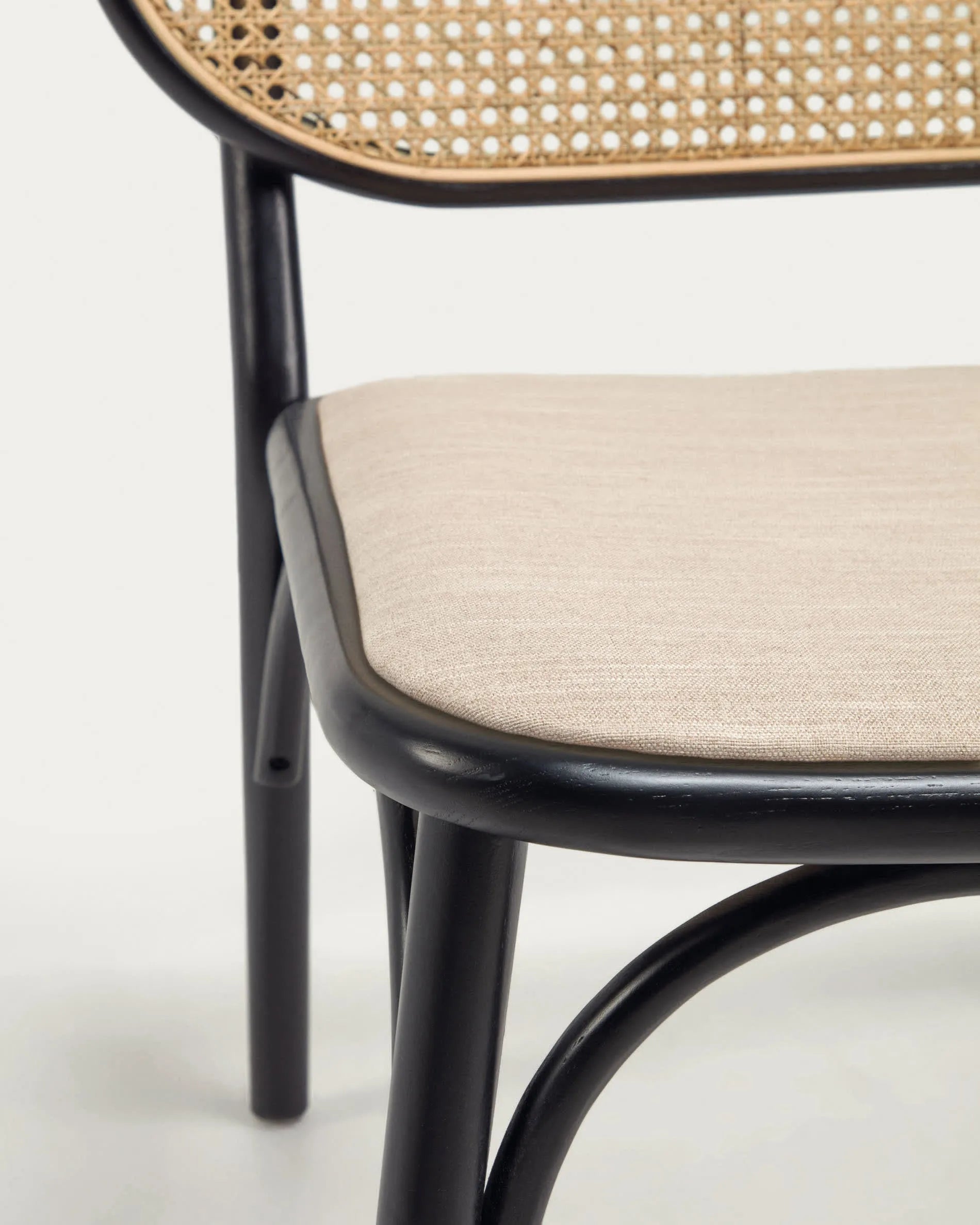 Eleganter Sessel aus massiver Ulme mit schwarzem Finish, Rattanrücken und wasserabweisender Polsterung für stilvollen Komfort.