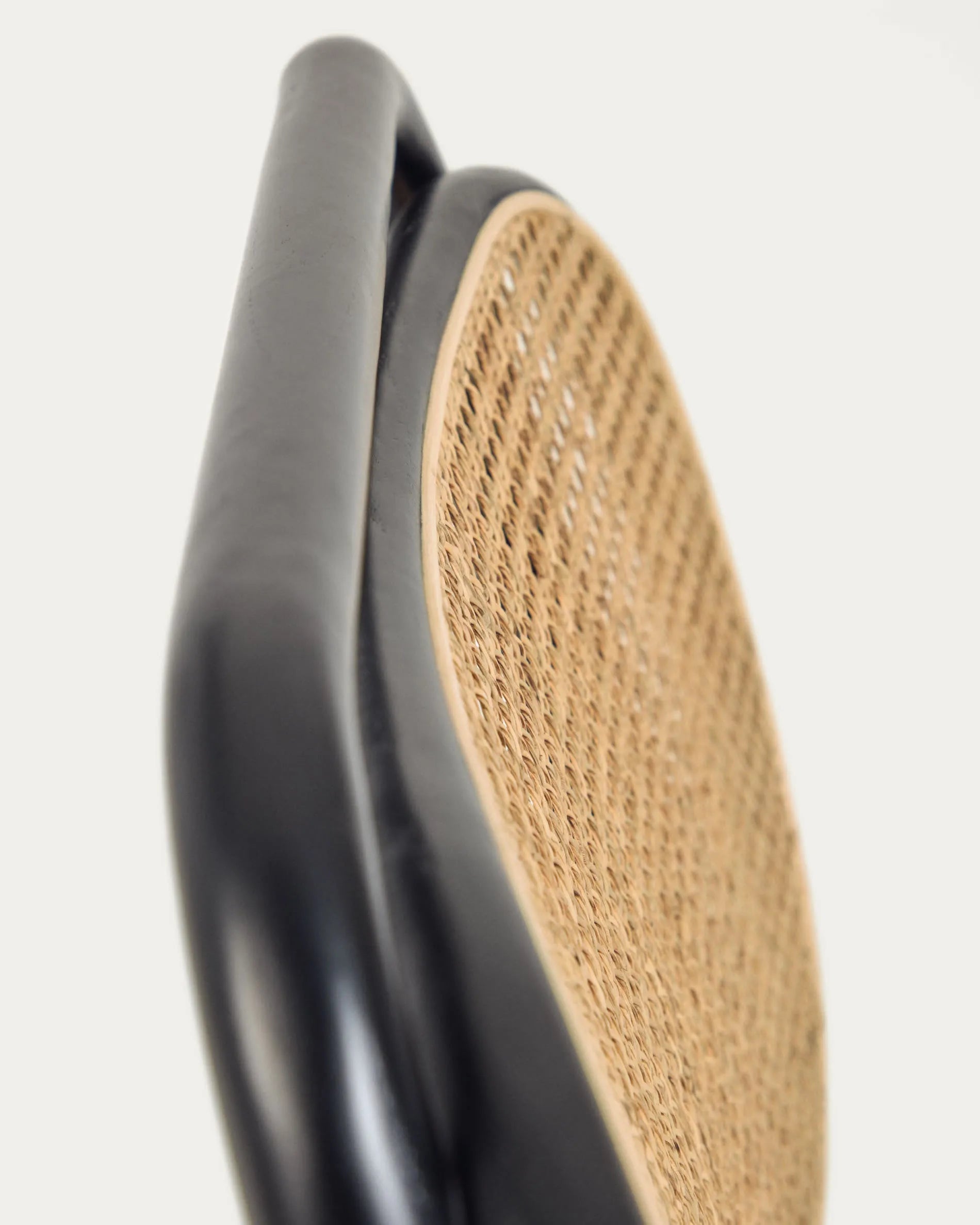 Eleganter Sessel aus massiver Ulme mit schwarzem Finish, Rattanrücken und wasserabweisender Polsterung für stilvollen Komfort.
