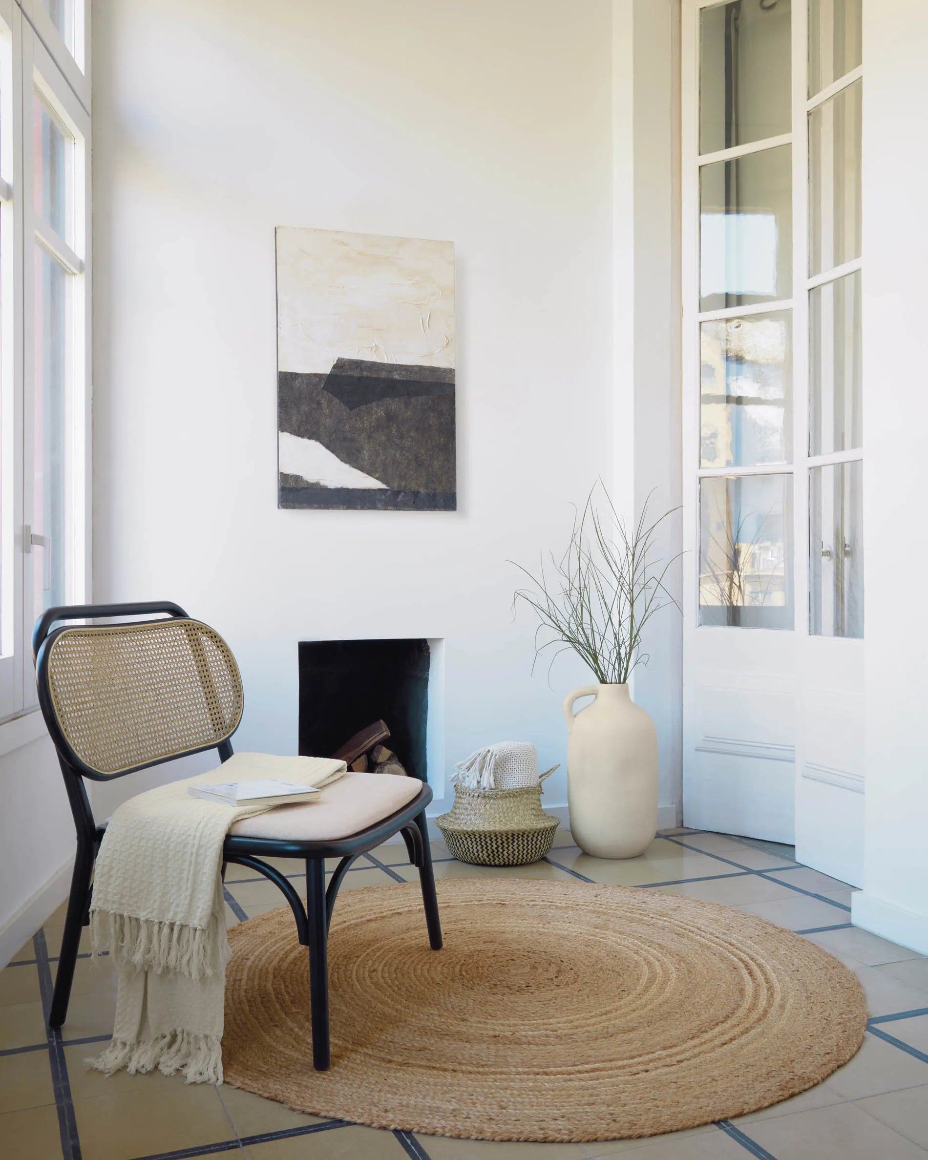 Eleganter Sessel aus massiver Ulme mit schwarzem Finish, Rattanrücken und wasserabweisender Polsterung für stilvollen Komfort.