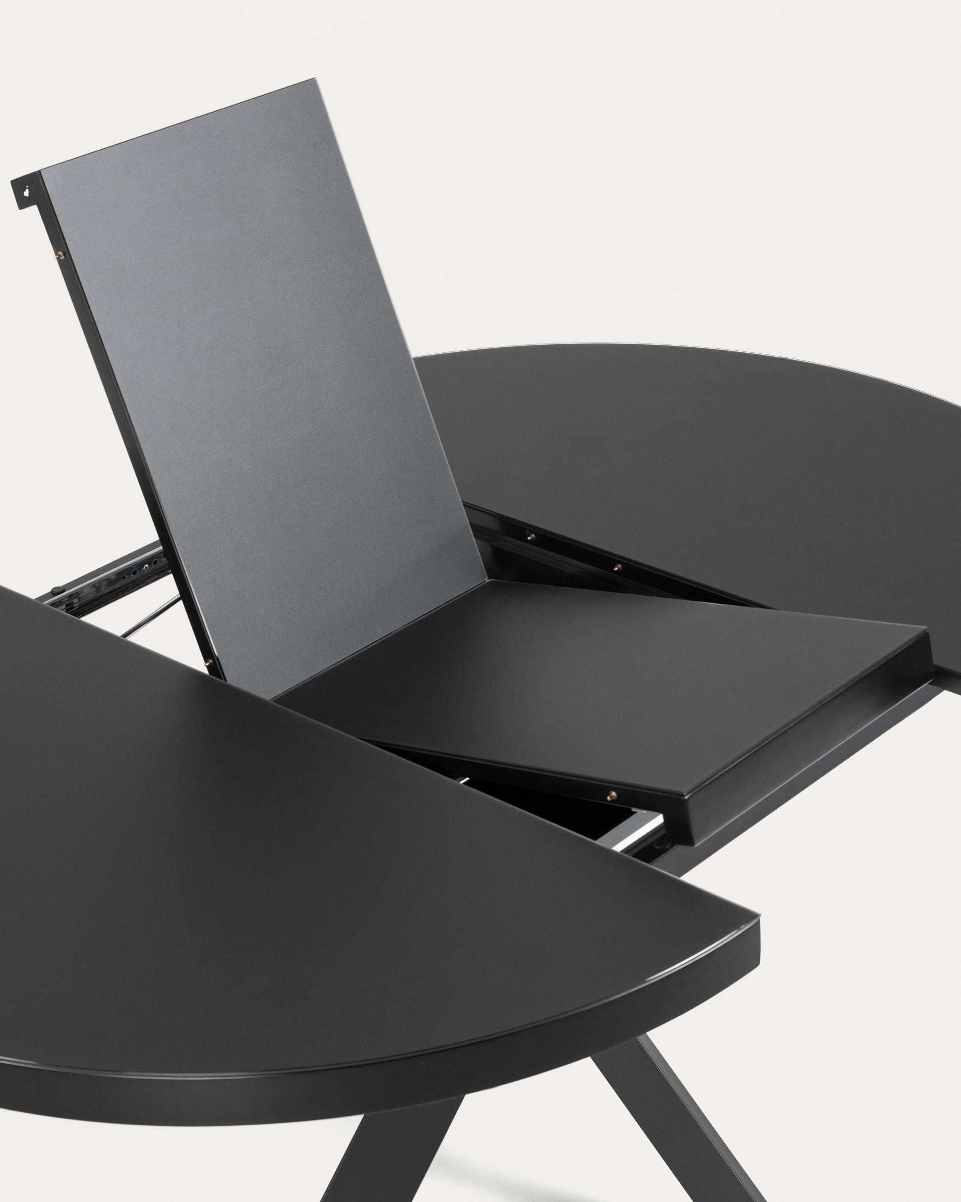 Eleganter runder Ausziehtisch mit Glasplatte und schwarzen Stahlbeinen, Ø 120-160 cm, perfekt für moderne Wohnräume.
