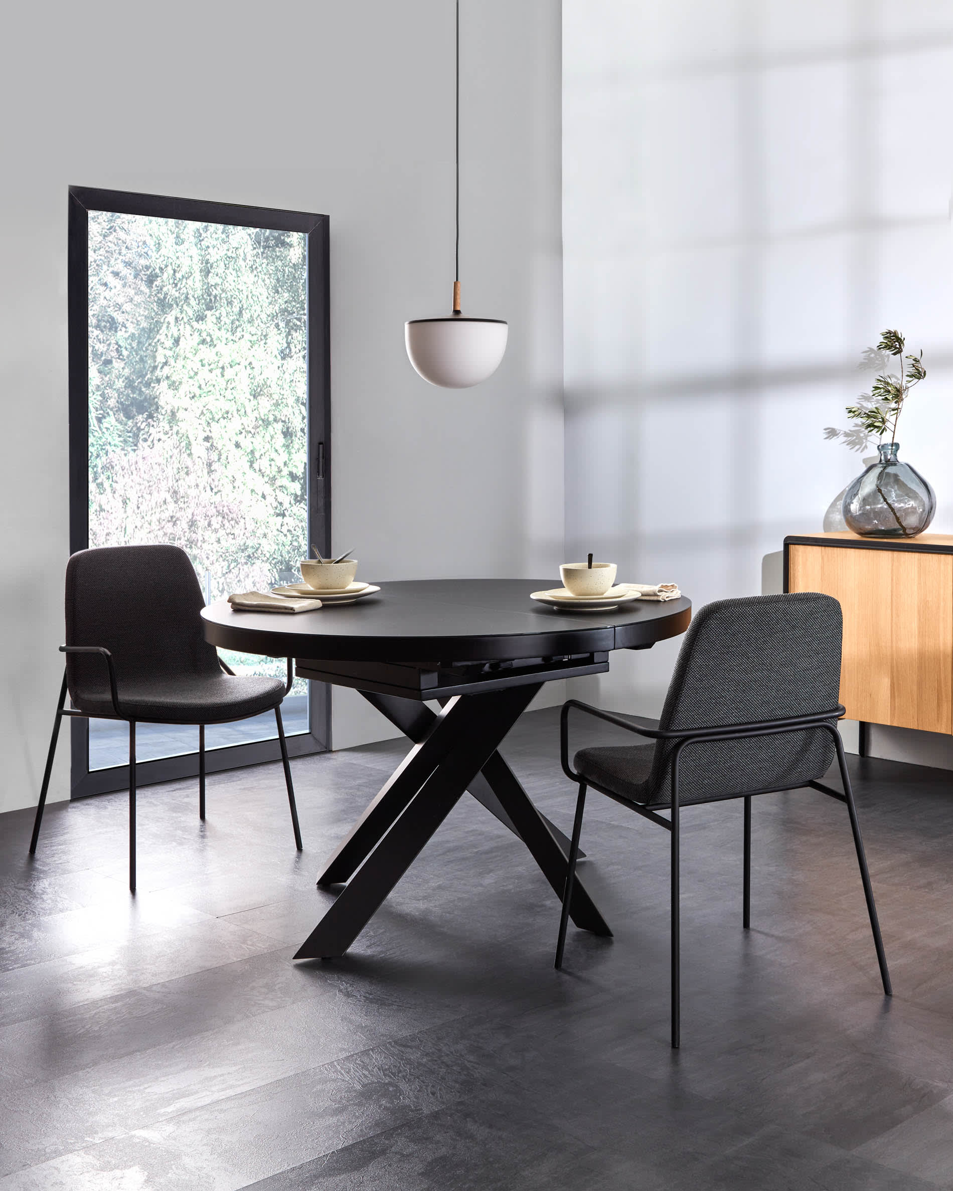 Moderner runder Ausziehtisch mit Glasplatte und schwarzen Stahlbeinen, Ø 120-160 cm, ideal für stilvolle Esszimmer.