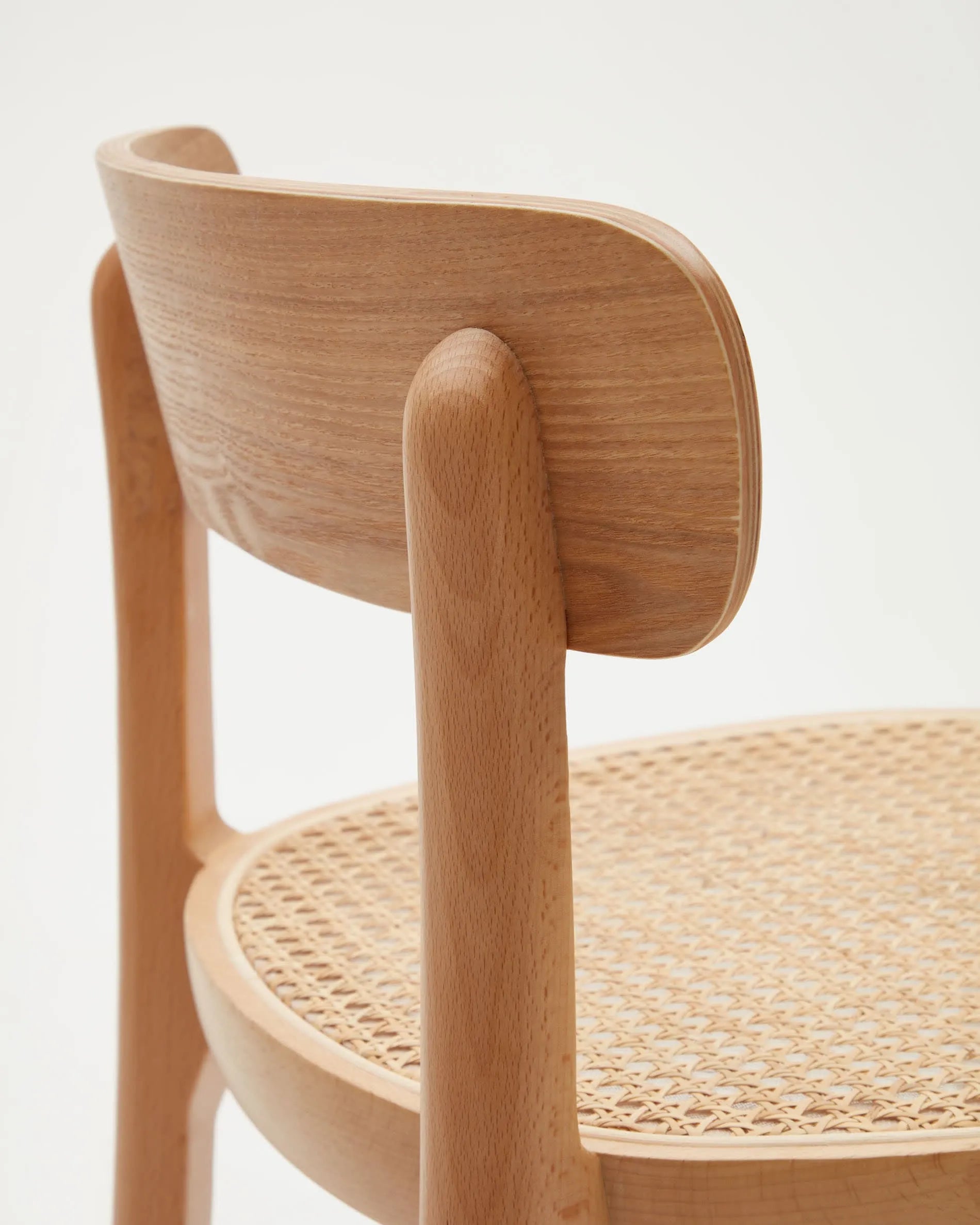 Der Romane Hocker vereint Buchenholz, Eschenfurnier und Rattan zu einem eleganten, stabilen Sitzmöbel für moderne Kücheninseln.