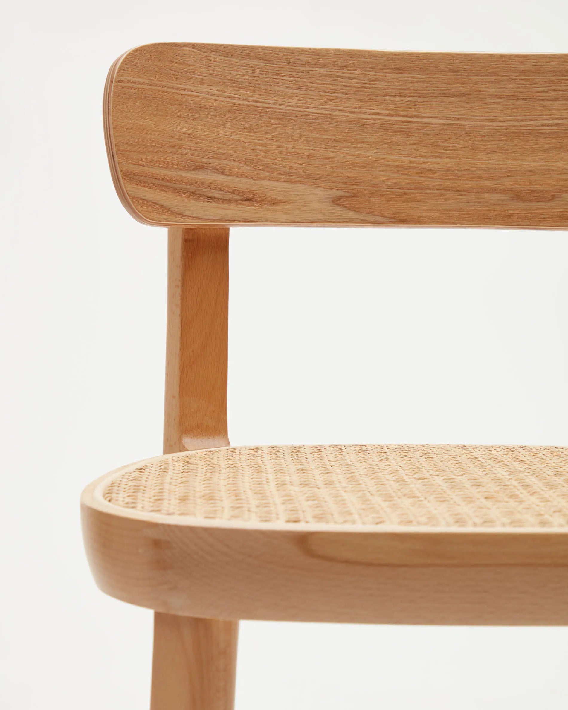 Der Romane Hocker vereint Buchenholz, Eschenfurnier und Rattan zu einem eleganten, stabilen Sitzmöbel für moderne Kücheninseln.