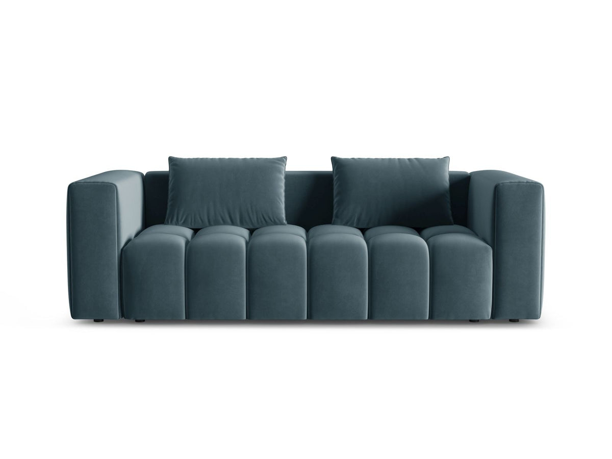 Sandfarbenes Samt-Bettsofa Verona mit drei Sitzplätzen, ausklappbarer Liegefläche, Bettkasten und schwarzen Kunststoffbeinen im Wohnraum.