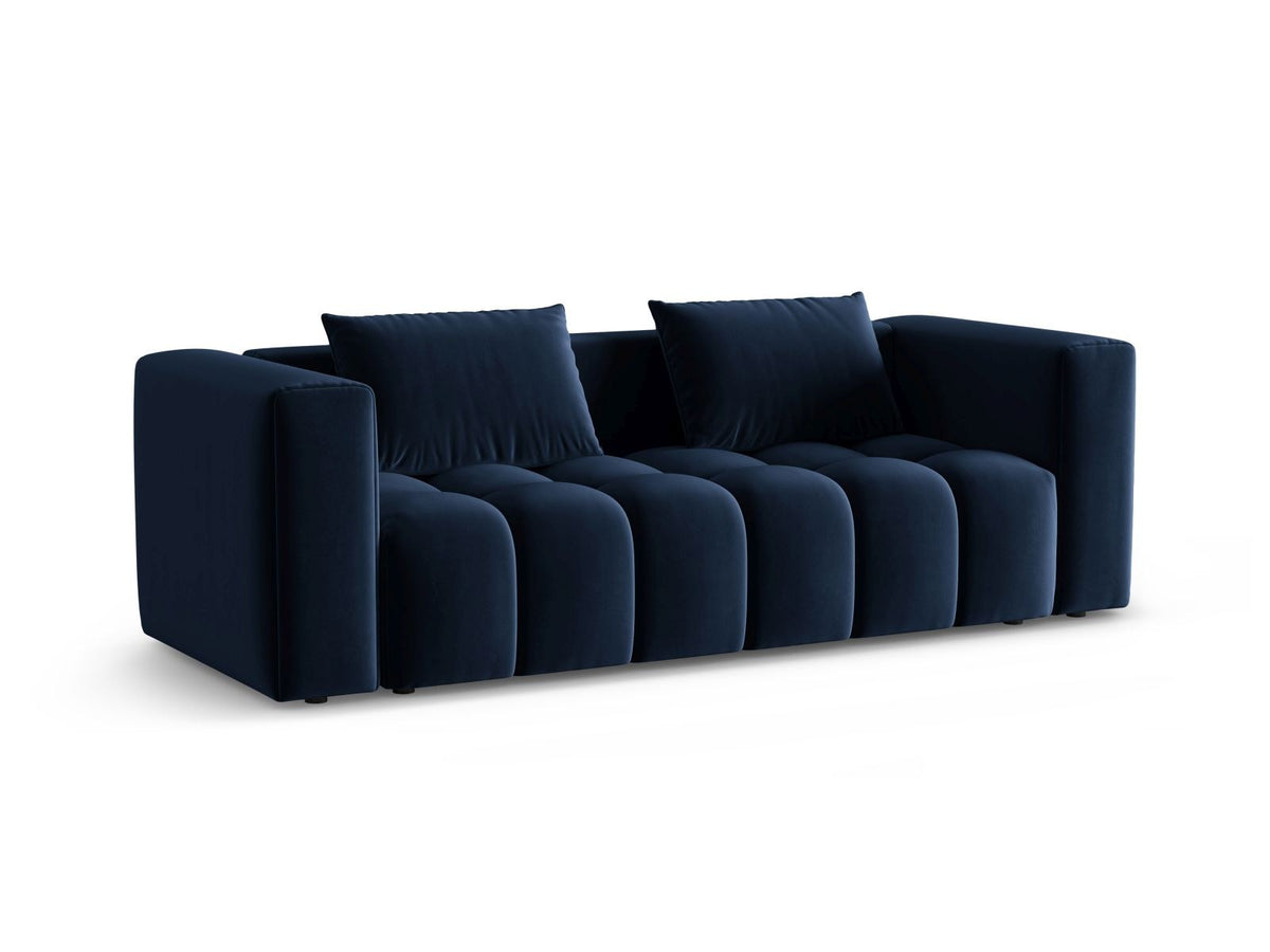 Sandfarbenes Samt-Bettsofa Verona mit drei Sitzplätzen, ausklappbarer Liegefläche, Bettkasten und schwarzen Kunststoffbeinen im Wohnraum.