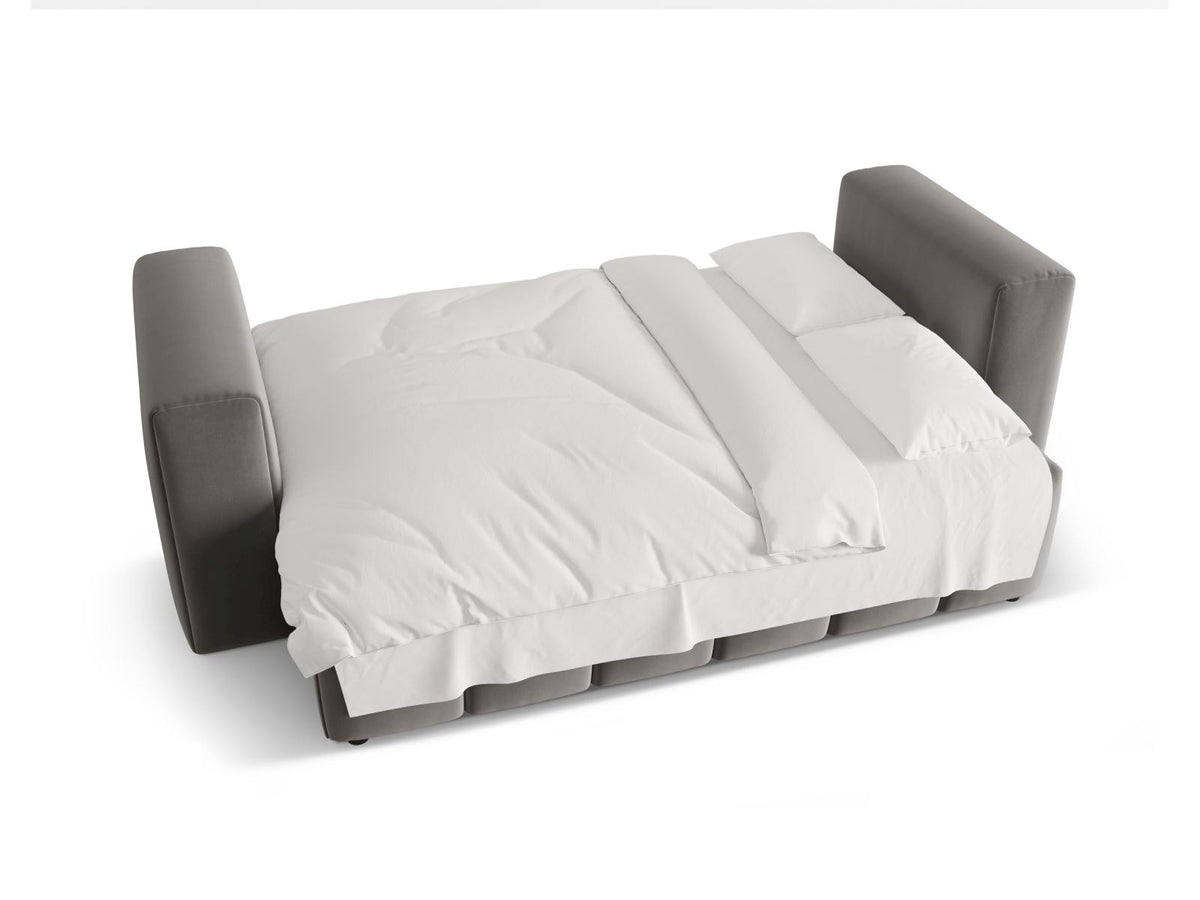 Sandfarbenes Samt-Bettsofa Verona mit drei Sitzplätzen, ausklappbarer Liegefläche, Bettkasten und schwarzen Kunststoffbeinen im Wohnraum.