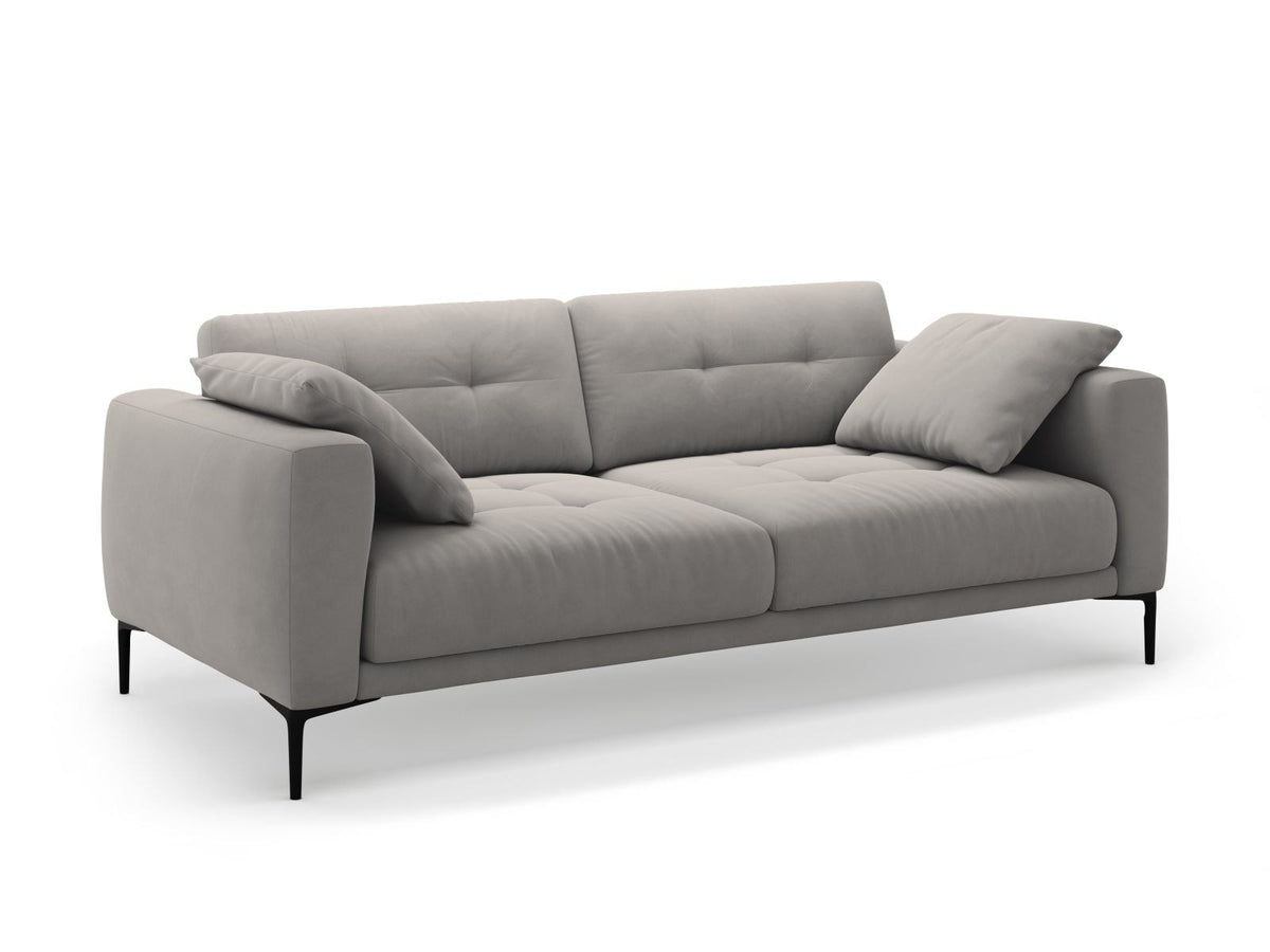 Beige Samt-Sofa Lazio mit 4 Sitzplätzen, Massivholzrahmen, Sitzpolster und schwarzen Metallbeinen, Frontalansicht im Wohnraum.
