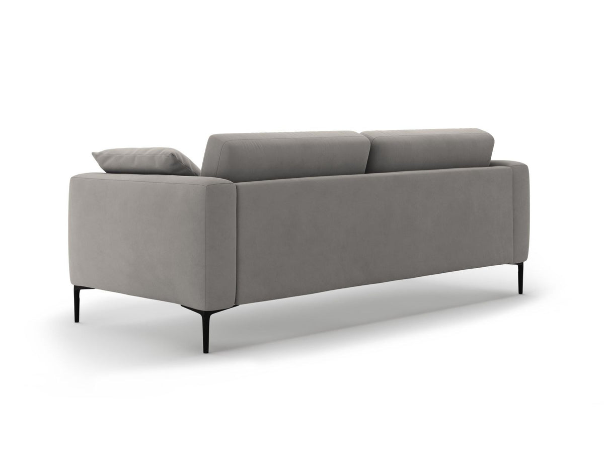 Beige Samt-Sofa Lazio mit 4 Sitzplätzen, Massivholzrahmen, Sitzpolster und schwarzen Metallbeinen, Frontalansicht im Wohnraum.
