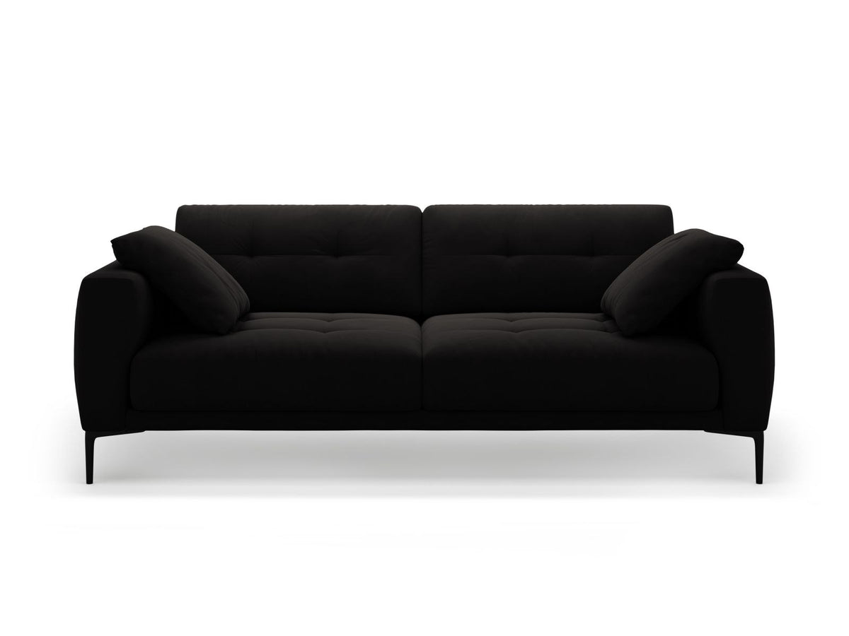 Beige Samt-Sofa Lazio mit 4 Sitzplätzen, Massivholzrahmen, Sitzpolster und schwarzen Metallbeinen, Frontalansicht im Wohnraum.