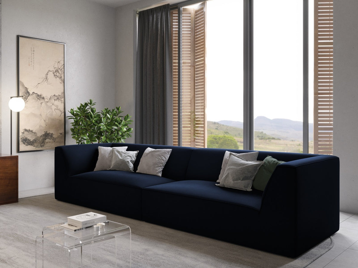 Beige-farbenes 4er Sofa Siena mit Samtbezug, schwarzen Kunststoffbeinen und gepolsterter Rückenlehne, Frontalansicht auf hellem Hintergrund.