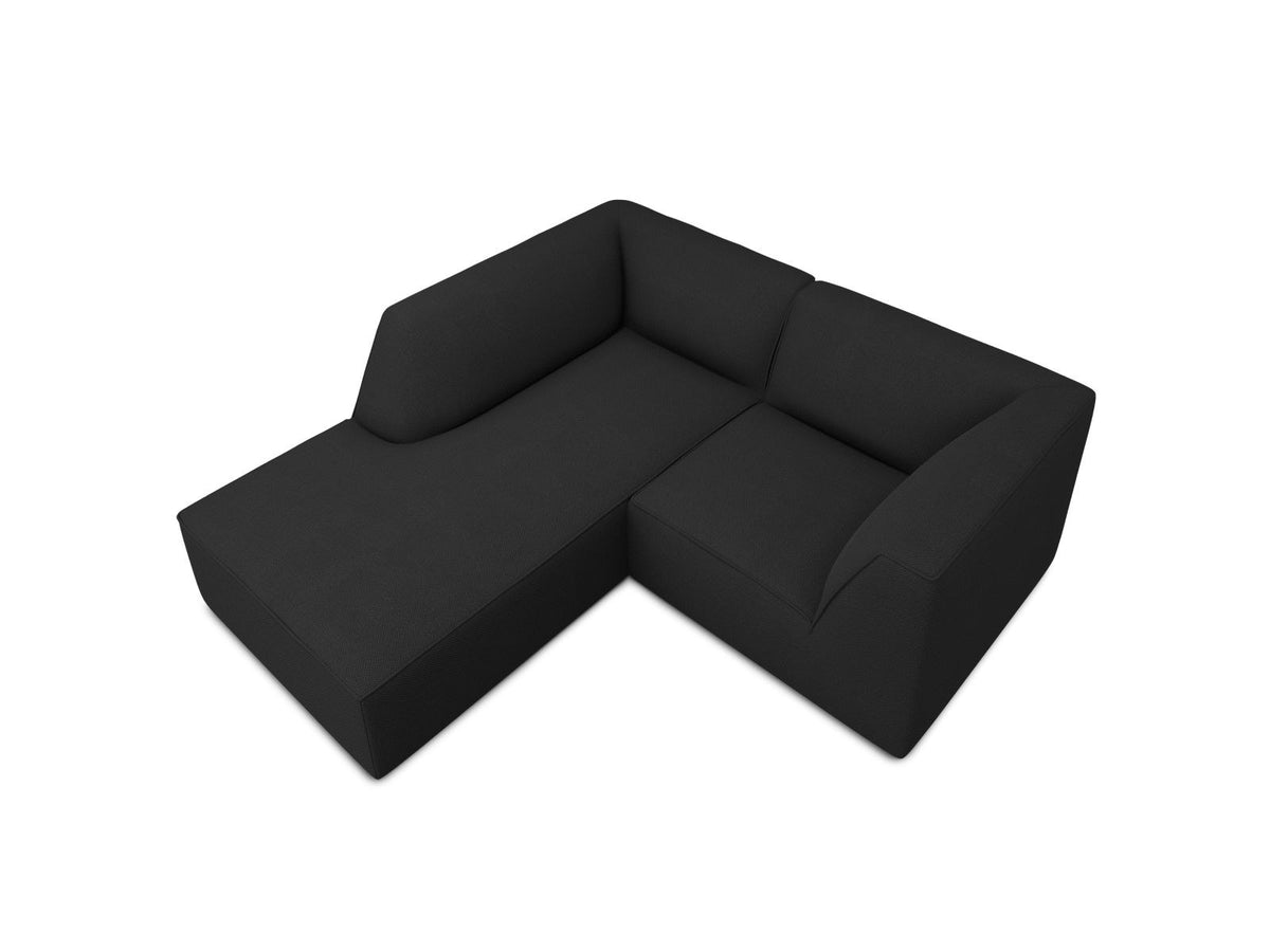 Modulares Ecksofa Siena mit gelbem Ottawa-Stoffbezug, schwarzen Kunststoffbeinen und Récamiere, Ansicht von vorne im Wohnraum.