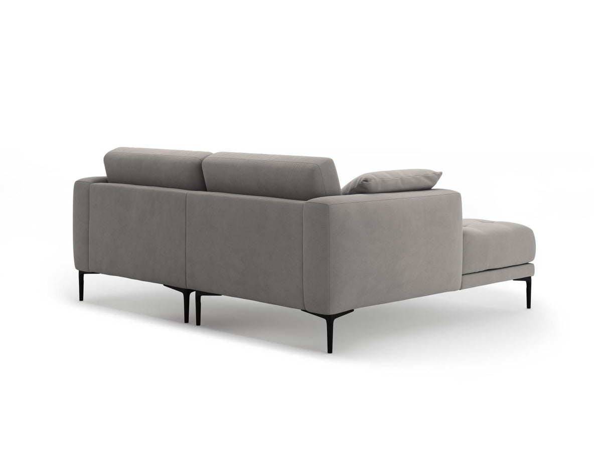 Beige-farbenes Samtsofa Lazio als 2-Sitzer Ecksofa links mit Récamiere, Massivholzrahmen und schwarzen Metallbeinen, Frontalansicht.