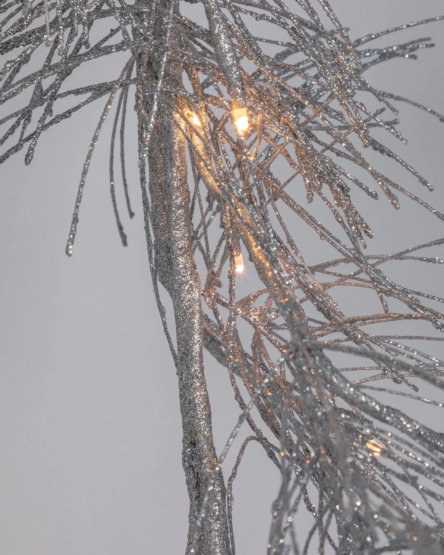 Elegante 180 cm lange silberne Zweig-Lichtergirlande, die mit funkelndem Glaslicht für festliche Atmosphäre sorgt.