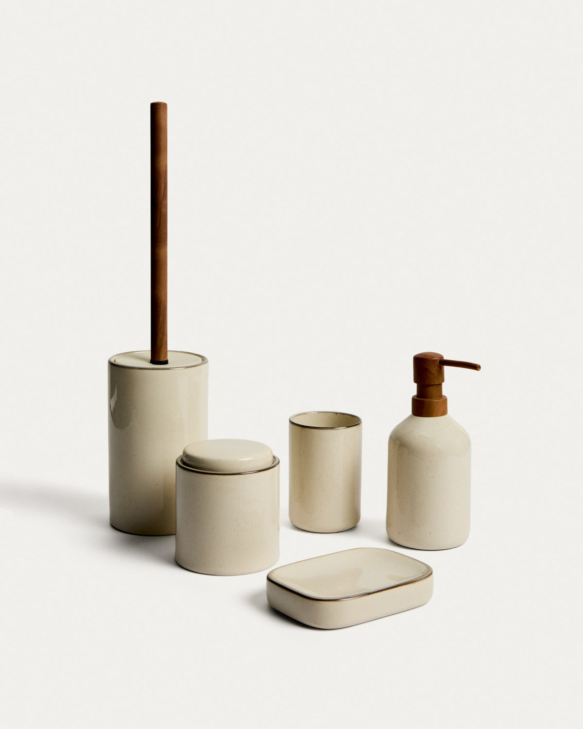 Foto einer schlanken Toilettenbürste aus glasiertem Steingut in Ecru mit Griff und Halter, Material teils Eisen und Polypropylen.