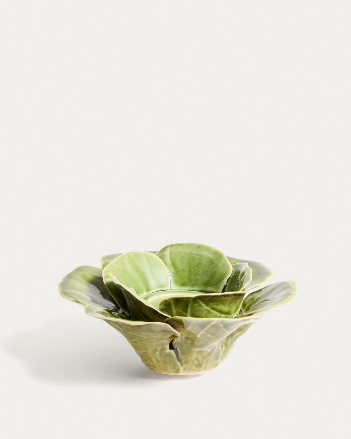 Kerzenständer aus glasierter Keramik in Hellgrün mit floralen, handgeformten Blütenelementen, Durchmesser 20 cm, Höhe 6 cm.