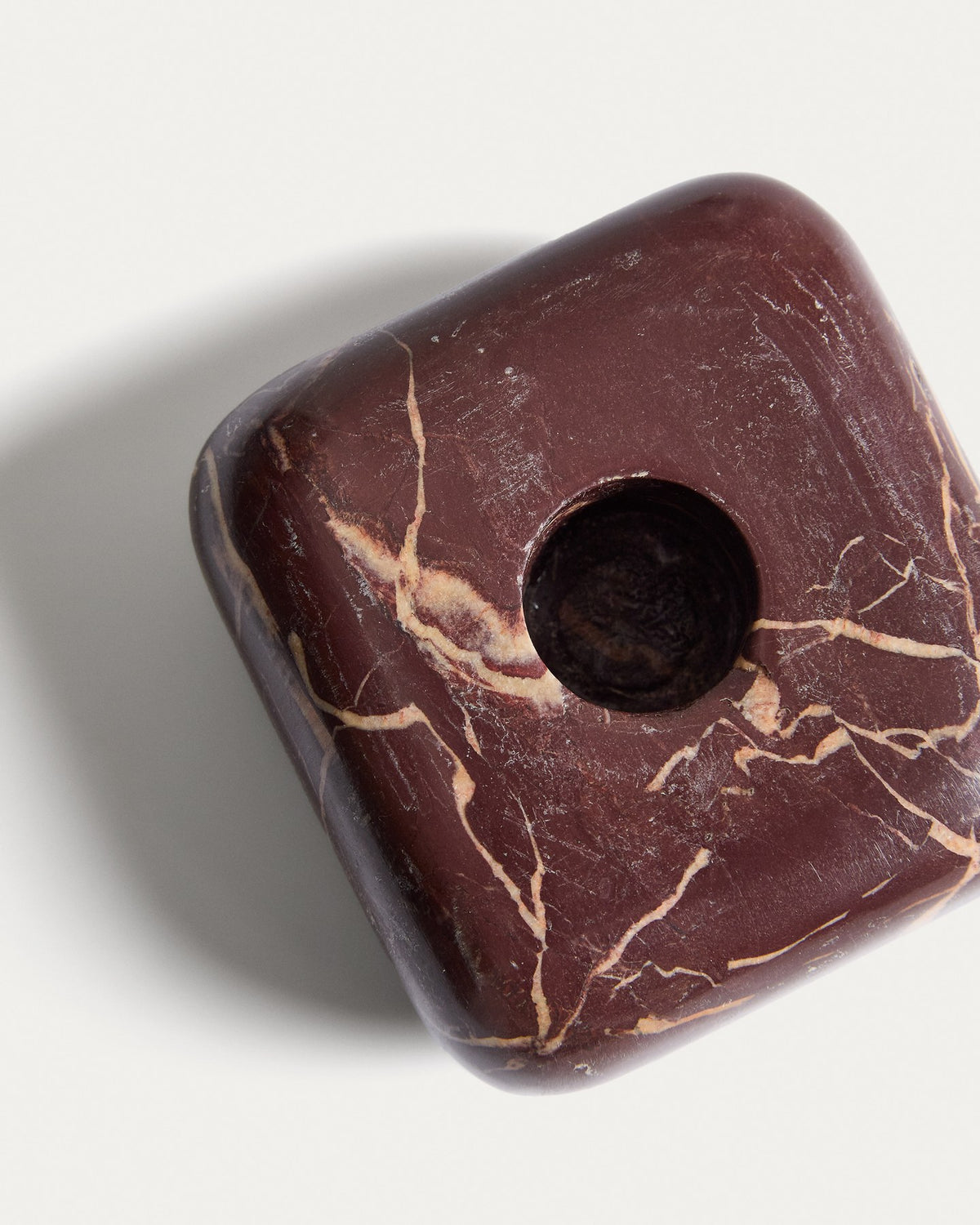 Kleiner runder Kerzenständer aus weinrotem Marmor mit naturbelassener Oberfläche und individueller Maserung, Höhe 4 cm.