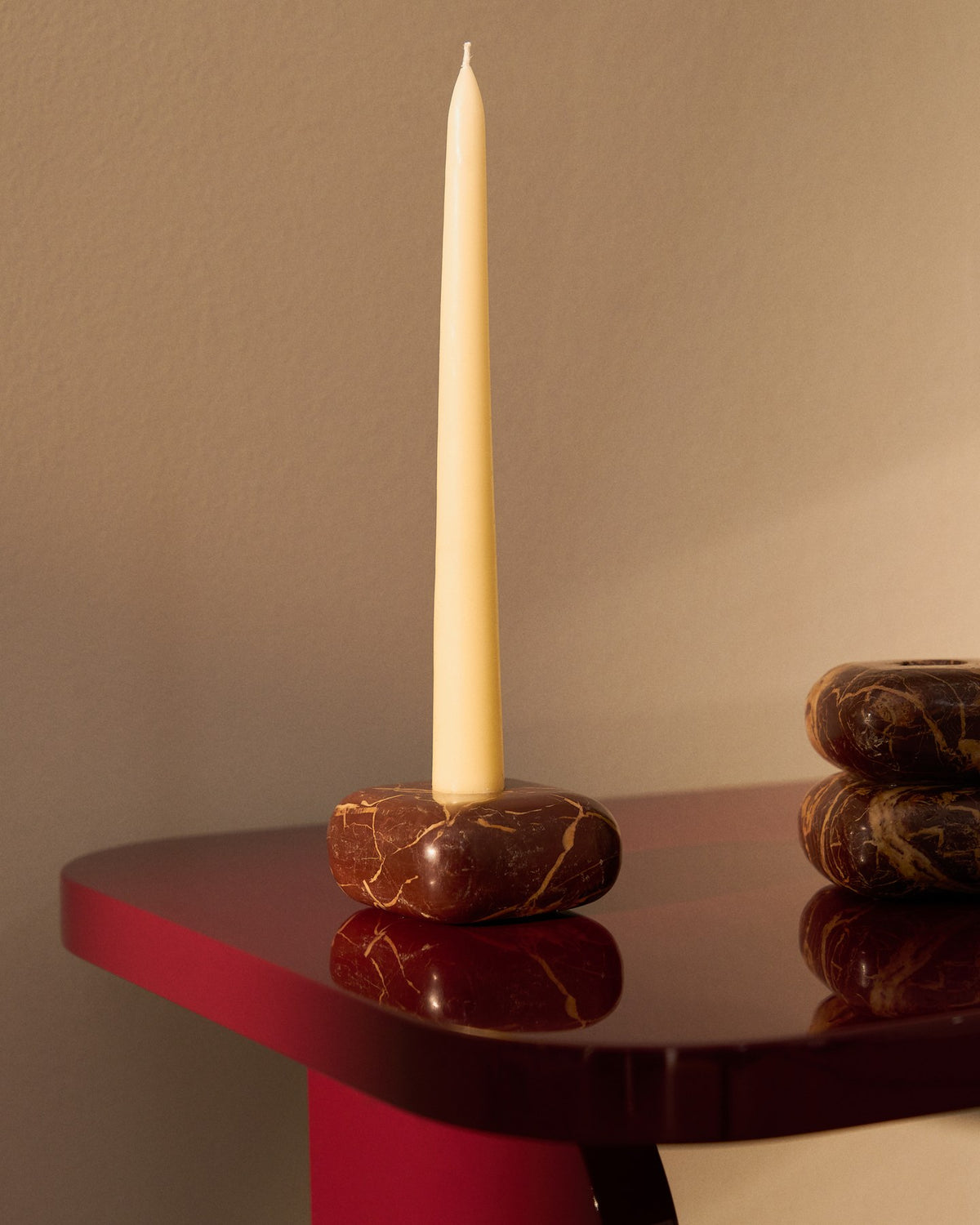 Kleiner runder Kerzenständer aus weinrotem Marmor mit naturbelassener Oberfläche und individueller Maserung, Höhe 4 cm.