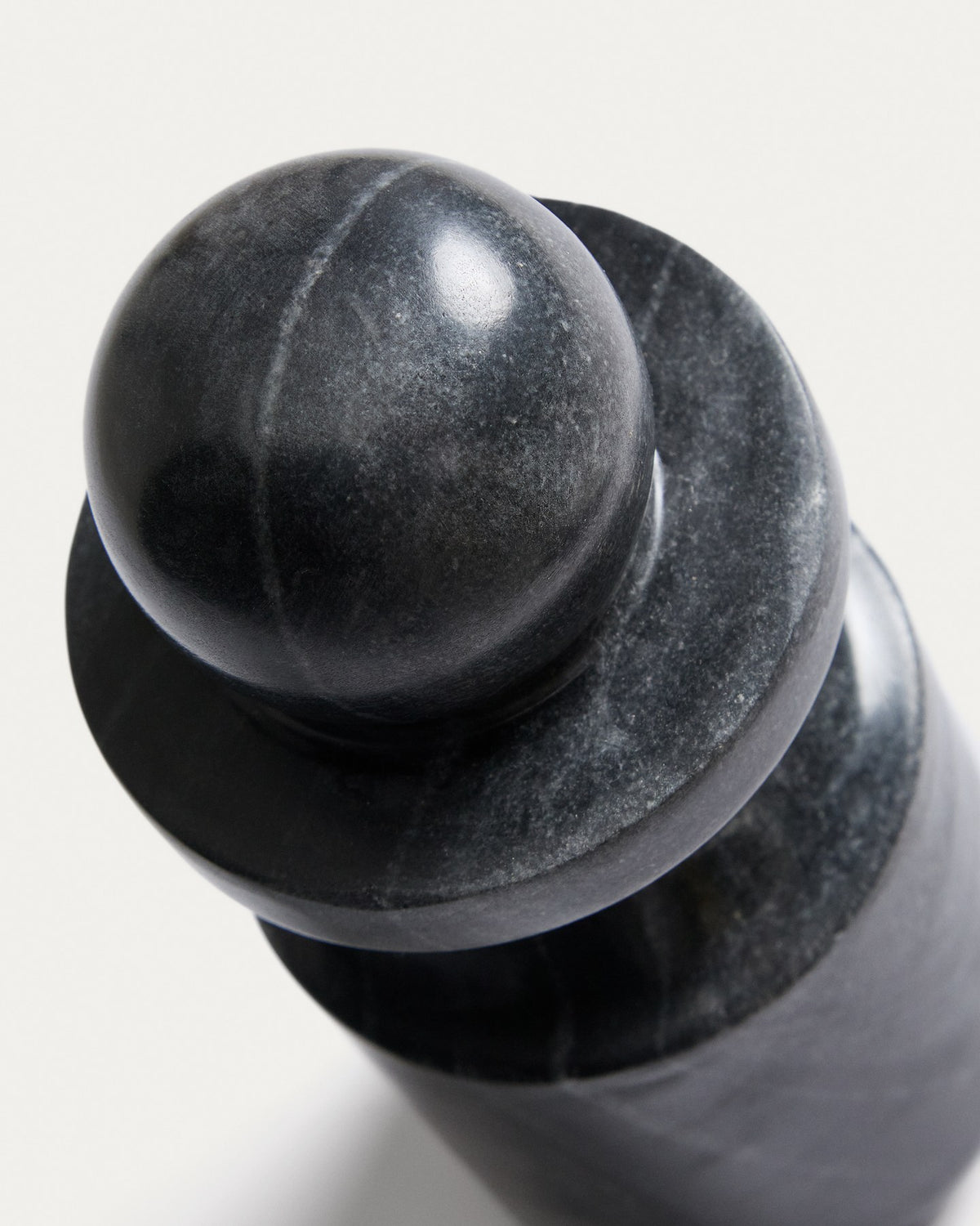 Graue Marmorskulptur Elvora von Kave Home mit schlichter, massiver Form, aufgenommen vor neutralem Hintergrund zur Ansicht der natürlichen Maserung.