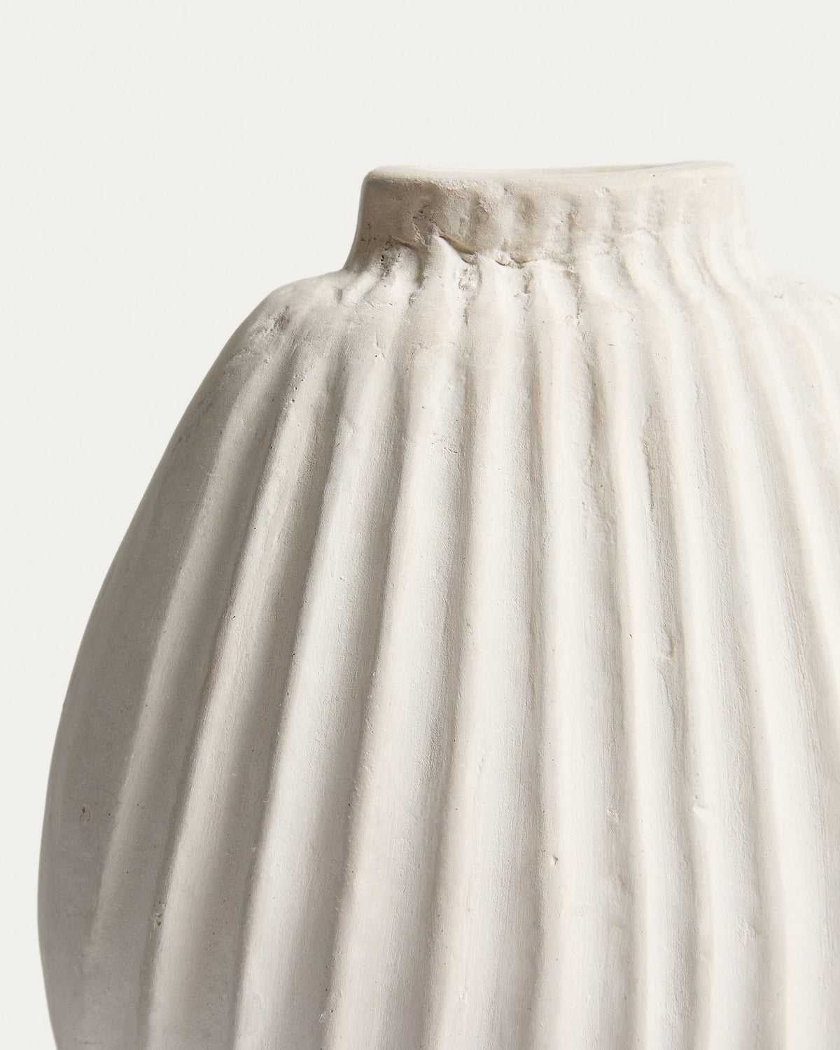 Handgefertigte Vase aus Pappmaché in der Farbe Ecru mit abgerundeter Form und feinen Relief-Linien auf der gesamten Oberfläche.