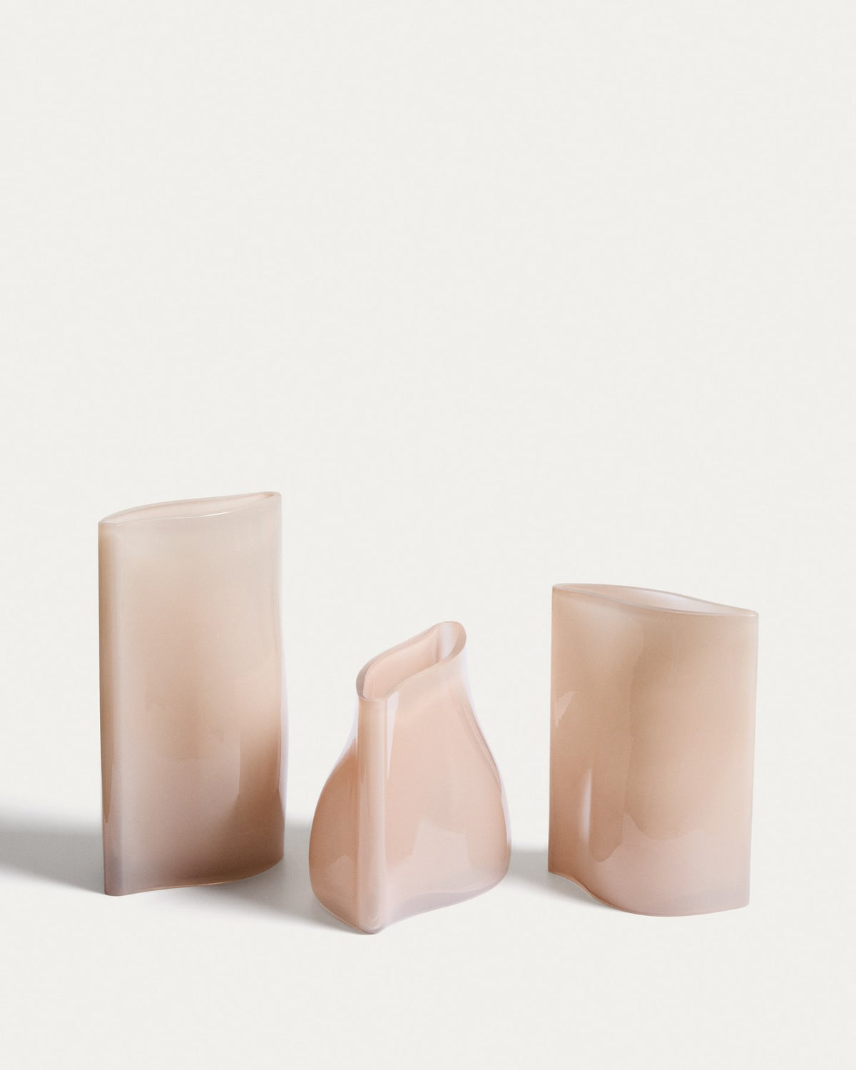Blassrosa Glas-Vase Ardeni von Kave Home, 28 cm hoch, schlanke Form aus durchgefärbtem Glas mit schmaler Öffnung, freistehend fotografiert.