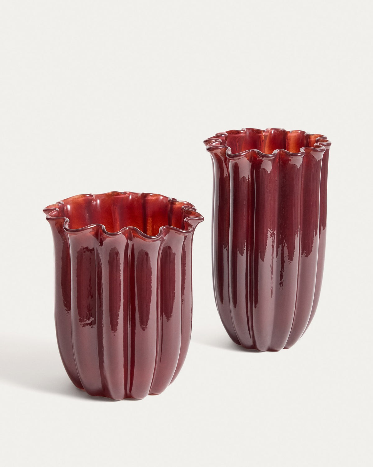 Burgunderrote Glas-Vase mit vertikalem Relief und rundem Öffnungsdurchmesser von 14,5 cm, Höhe 25 cm, aus durchgefärbtem Glas.