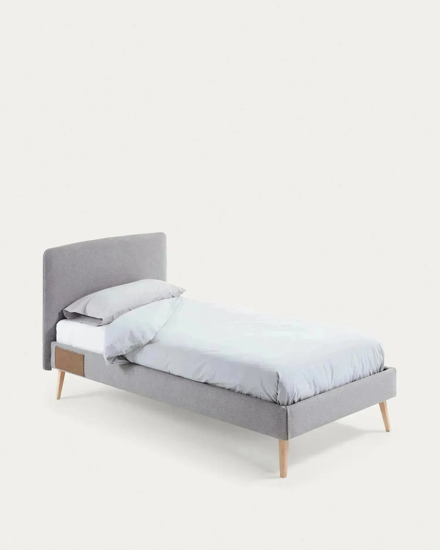 Elegantes Dyla Bett mit hellgrauem, abnehmbarem Bezug, massiven Buchenholzbeinen, ideal für 90x190 cm Matratzen, von Kave Home.