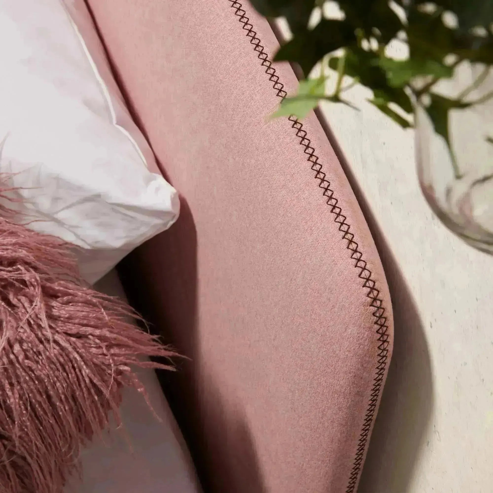 Das Dyla Bett von Kave Home kombiniert Stil und Funktionalität mit rosa Bezug, Buchenholzbeinen und Platz für eine 90x190 cm Matratze.