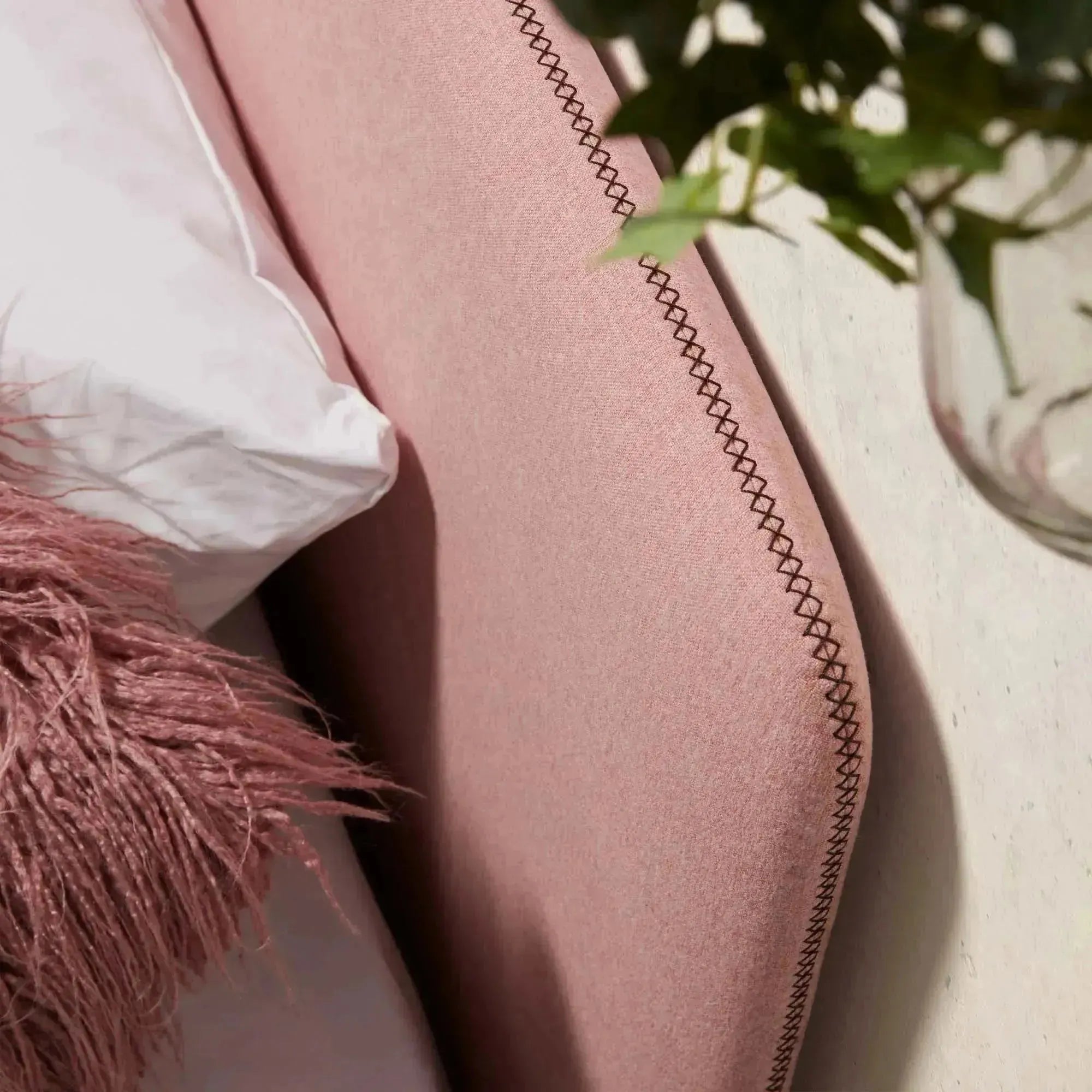 Das Dyla Bett von Kave Home kombiniert Stil und Funktionalität mit rosa Bezug, Buchenholzbeinen und Platz für eine 90x190 cm Matratze.