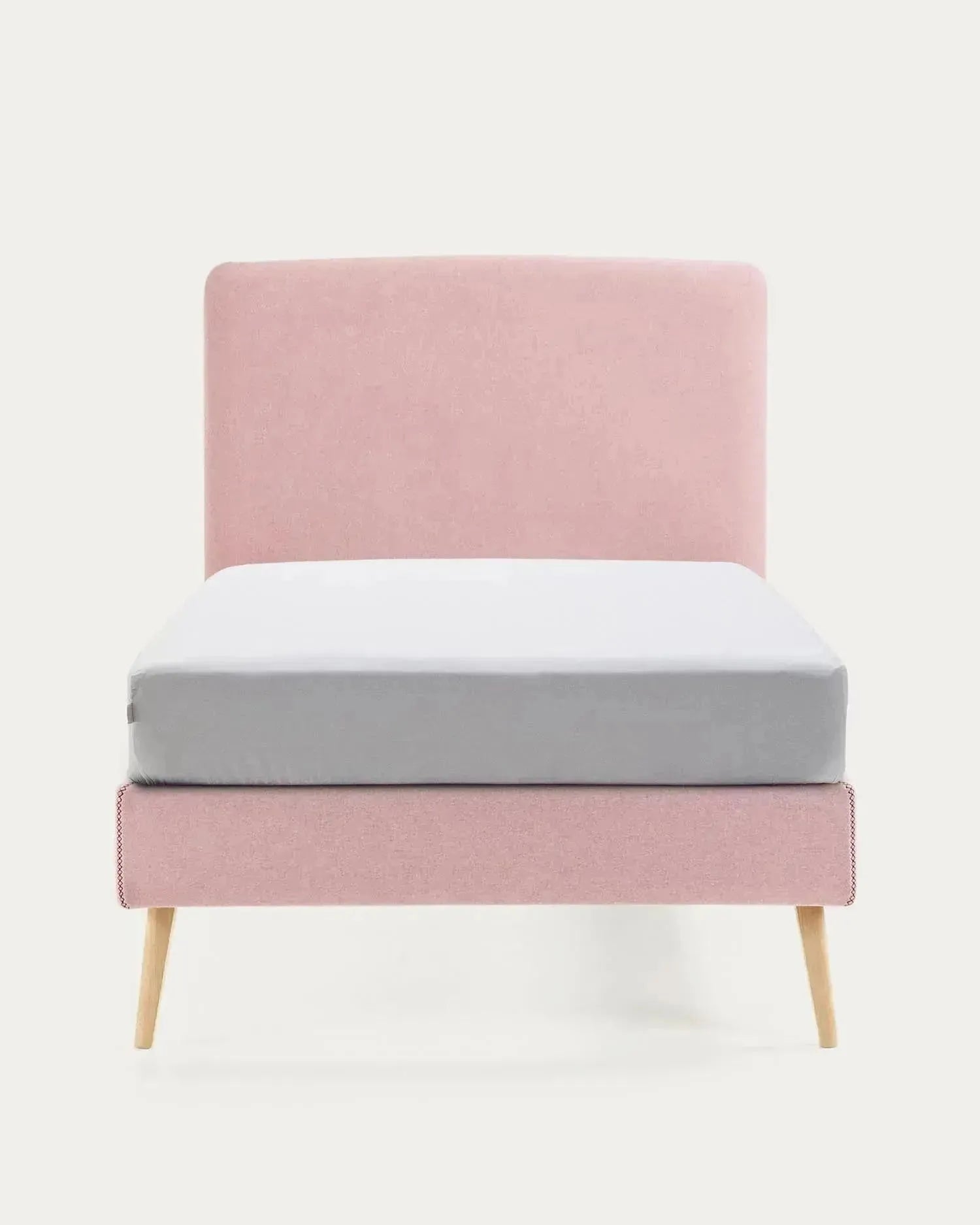 Das Dyla Bett von Kave Home kombiniert rosa abnehmbaren Bezug, massive Buchenholzbeine und 90x190 cm Matratzenmaß für Stil und Komfort.