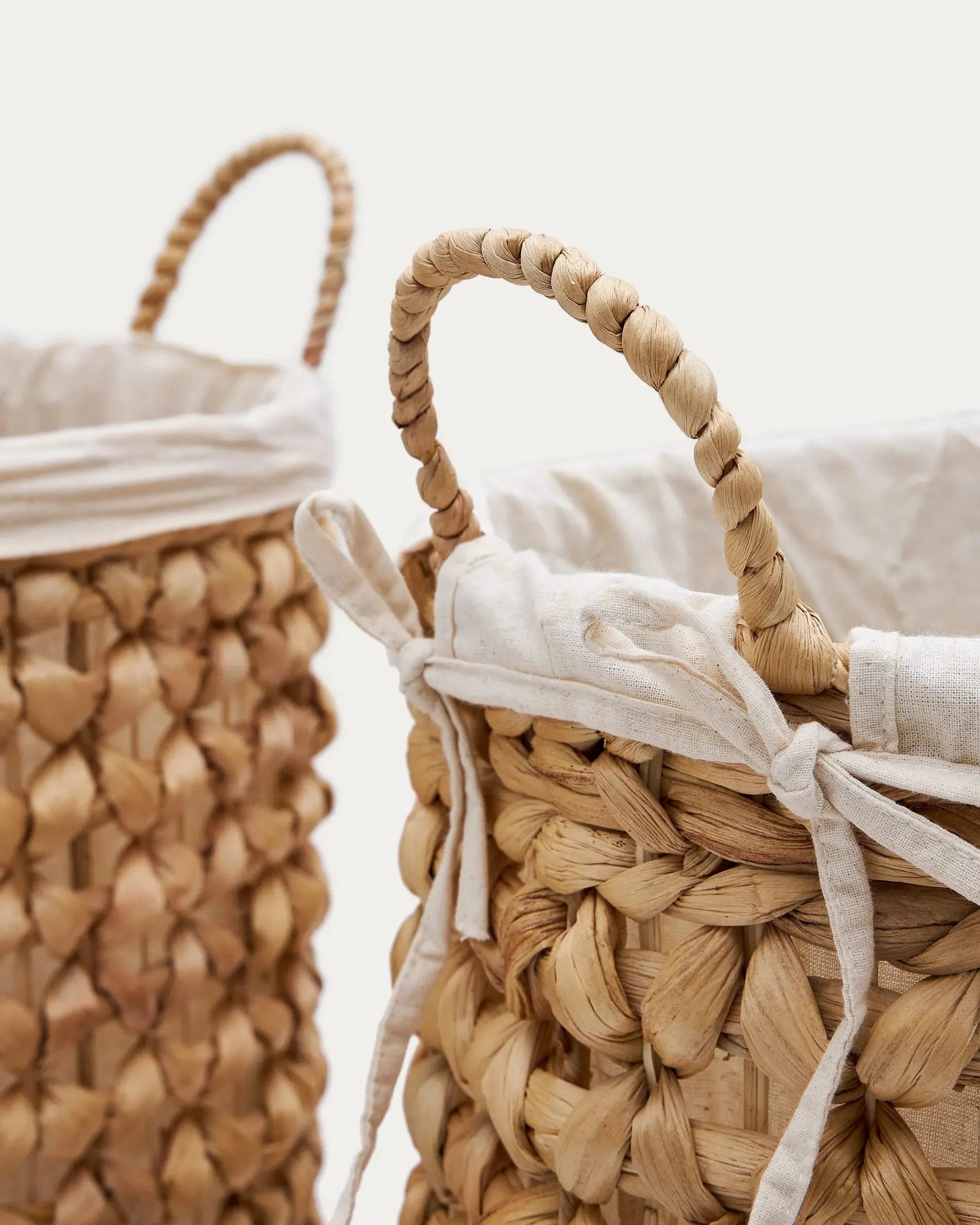 Das Tressa Set umfasst zwei elegante Wäschekörbe aus Naturfasern (50 cm und 60 cm), perfekt für stilvolles Wohnen.