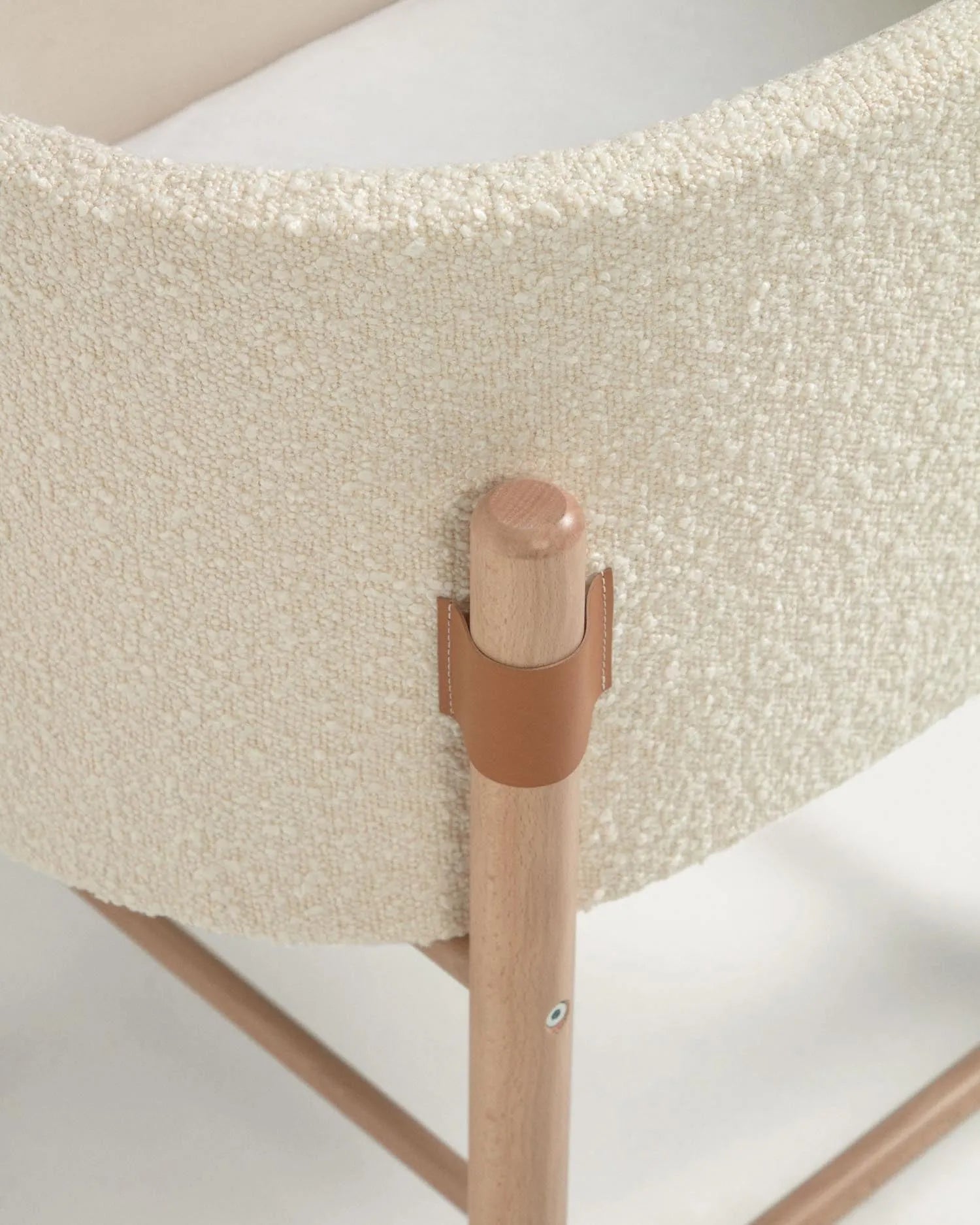 Eleganter Stubenwagen aus massivem Buchenholz mit weichem Bouclé-Bezug in Weiß, ideal für stilvolle und nachhaltige Babyzimmer.