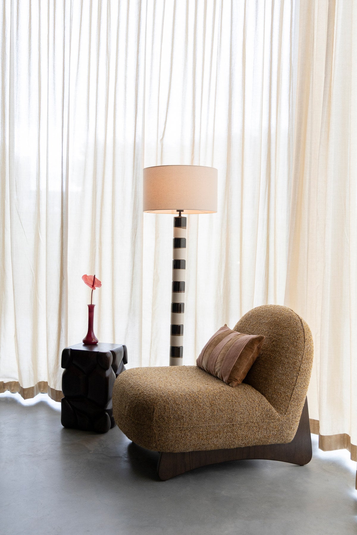 Sessel Loom mit rundem, grob gewebtem Bezug und dunklem Holzgestell in Kufenform