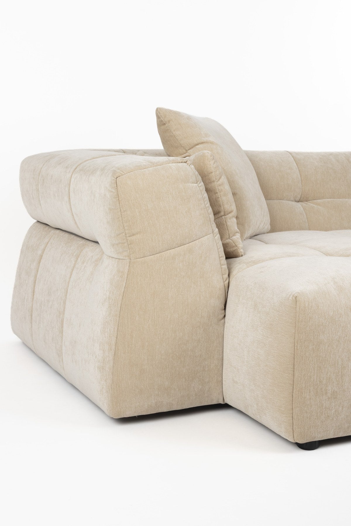 Beiges Ecksofa Hodge mit linksseitiger Chaiselongue, gesteppter Sitz- und Rückenlehne aus glänzendem Samtstoff, leicht nach aussen gebogene Armlehnen.