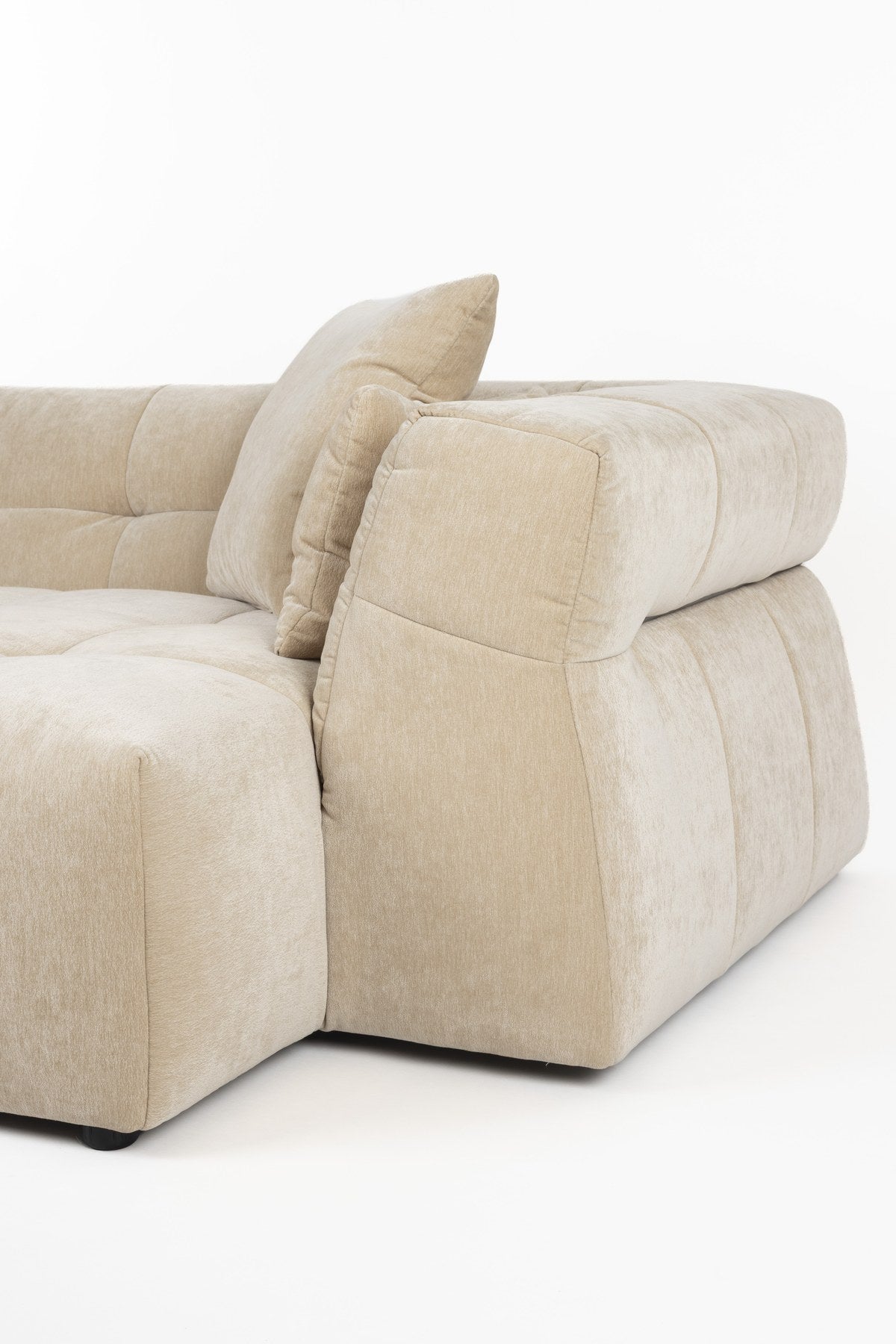 Beiges Ecksofa rechts Hodge von Dutchbone mit Samtbezug, gesteppter Sitz- und Rückenlehne sowie leicht nach aussen gebogenen Armlehnen.