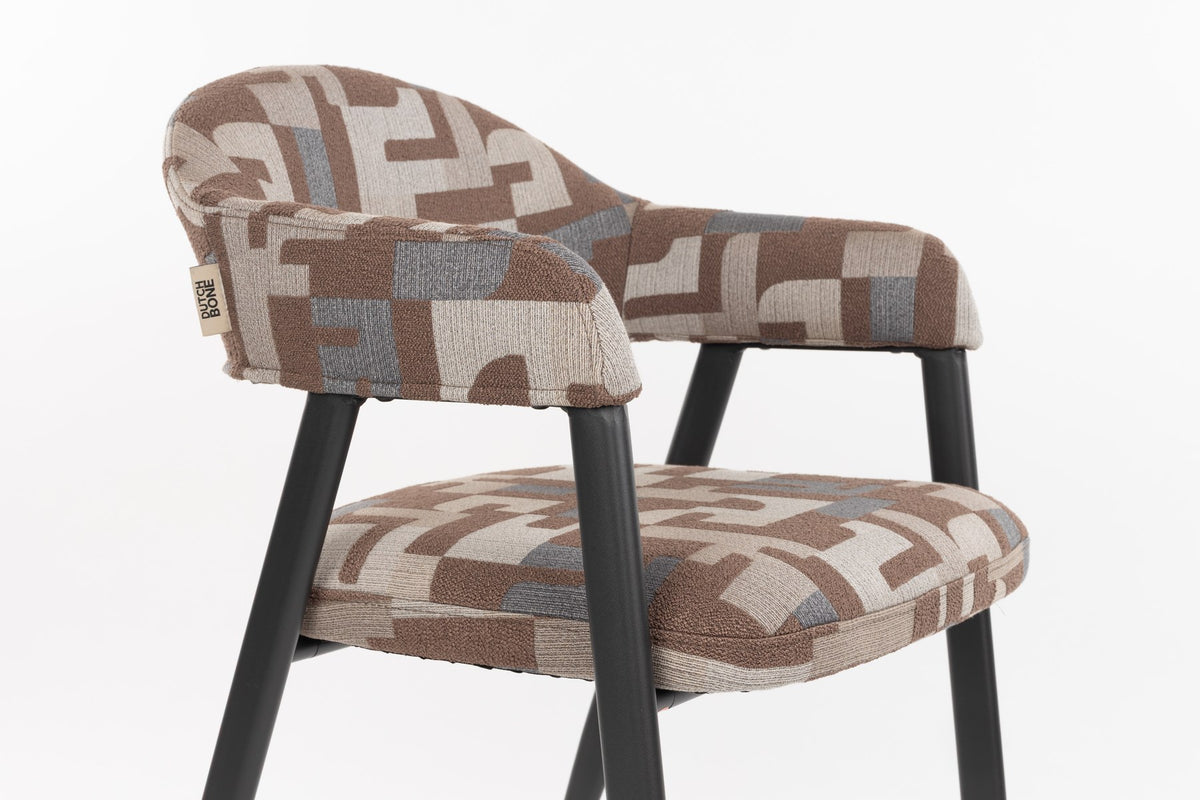 Esszimmerstuhl Chair Miyo Light Brown von Dutchbone mit hellbraunem gewebtem Bezug, grafischem Muster und schwarzem Metallgestell auf hellem Hintergrund