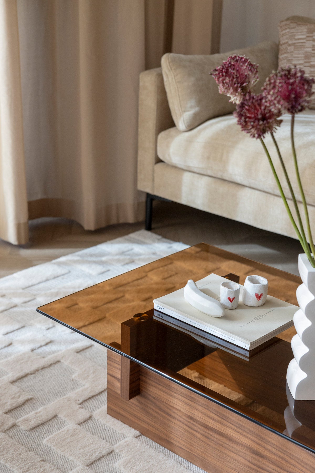 Couchtisch Lucifer Walnut von Dutchbone mit braunem Holzgestell aus zwei quer angeordneten Platten und rechteckiger Glasplatte.