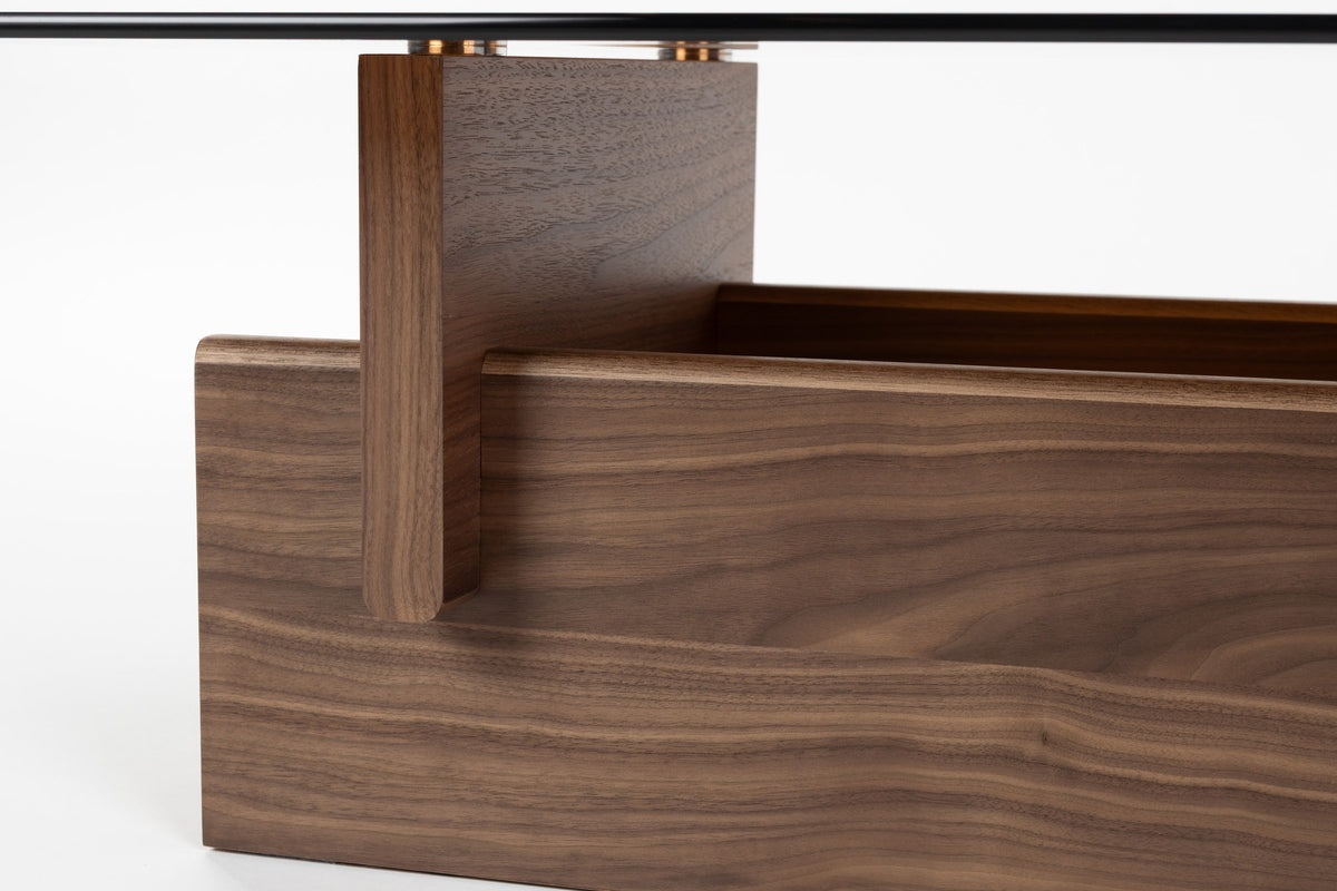 Couchtisch Lucifer Walnut von Dutchbone mit braunem Holzgestell aus zwei quer angeordneten Platten und rechteckiger Glasplatte.