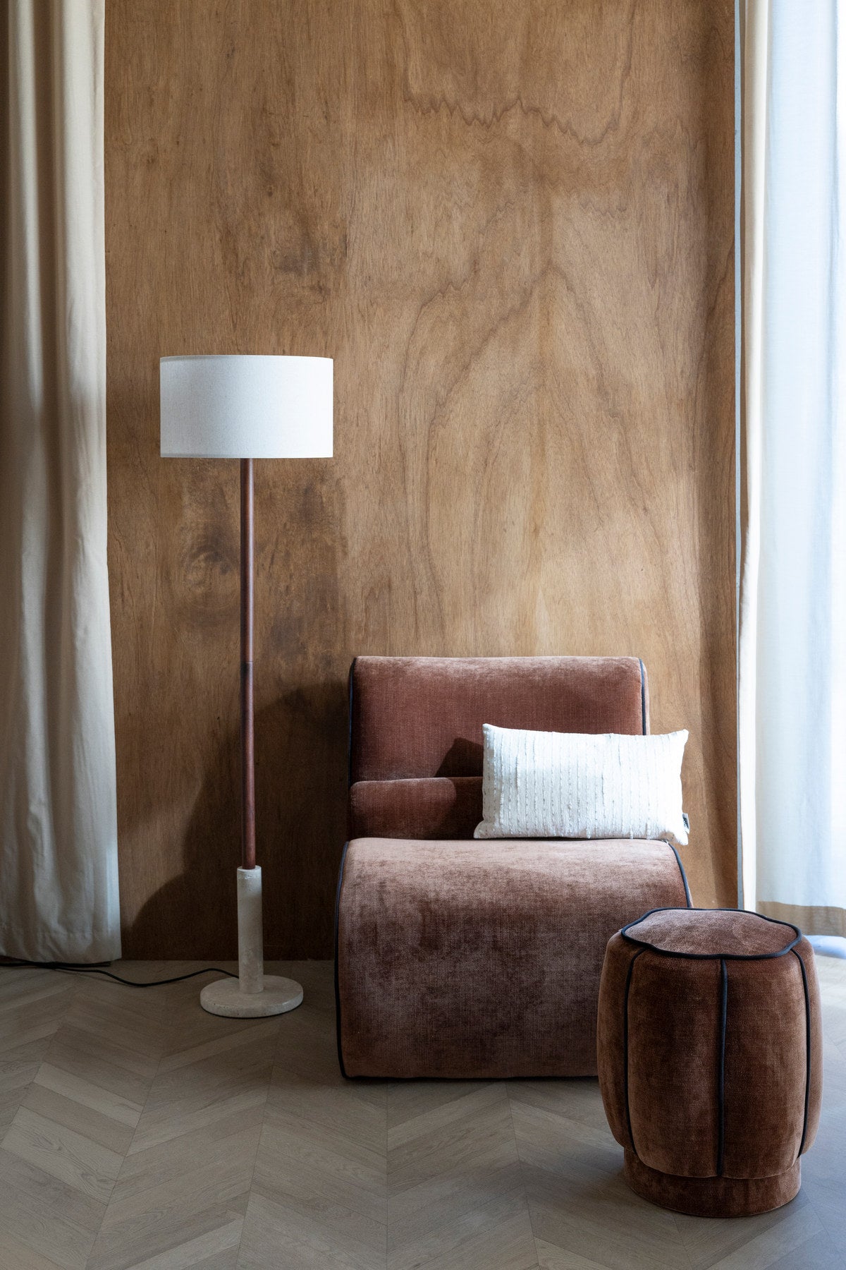 Runder Pouf mit dunkelbraunem Veloursbezug, gepolsterter Sitzfläche und dunklem Paspelrand, Hocker der Serie Donna von Dutchbone.