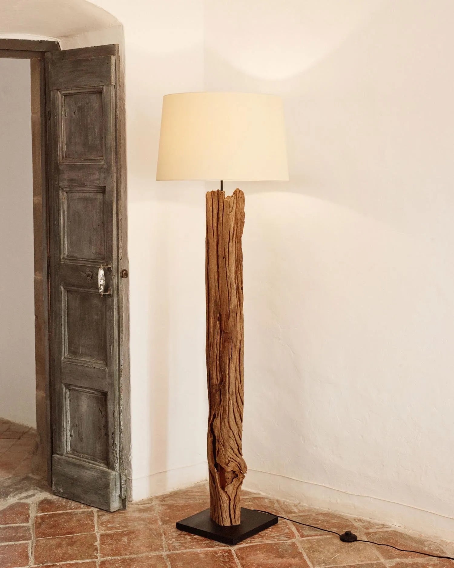 Die Powell Stehlampe kombiniert recyceltes Tropenholz mit einem Baumwollschirm für nachhaltige Eleganz und flexible Beleuchtung.