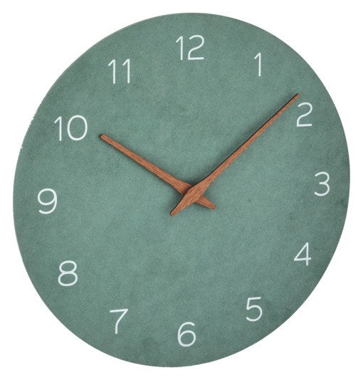 Runde TFA Wanduhr in Jadegrün mit Zeigern aus Walnussholz und Ziffernblatt aus MDF in Naturtönen, minimalistisches Design an weisser Wand.