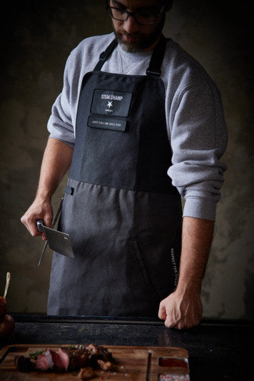 STEAK CHAMP Kochschürze 2 Taschen mit Klettverschluss für Beschriftung in Schwarz präsentiert im Onlineshop von KAQTU Design AG. Kochschürzen ist von STEAK CHAMP