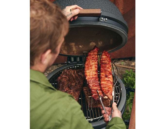 Multilevel Kochsystem XL von THE BASTARD, ideal für vielseitiges Grillen und Kochen im Freien, präsentiert in ansprechendem Ambiente.