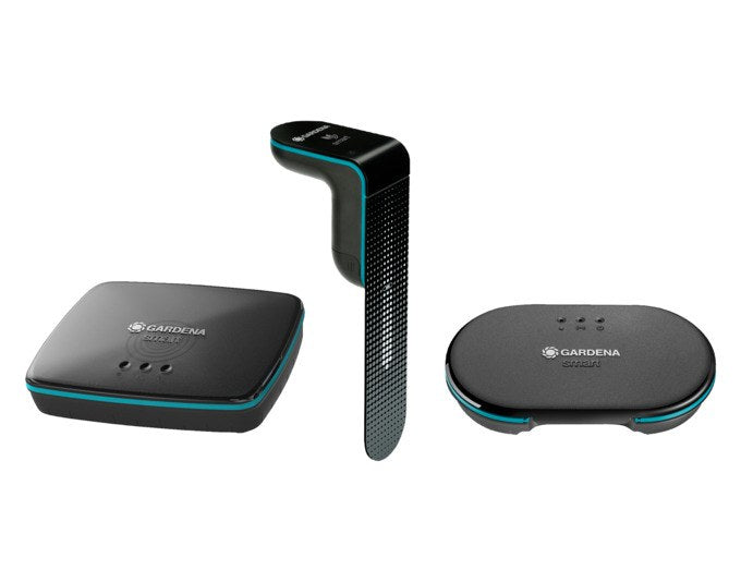 Schwarzes GARDENA Set Smart Irrigation Control mit Steuereinheit, Gateway, Bodenfeuchtesensor, LAN-Kabel und Netzteil auf weissem Hintergrund