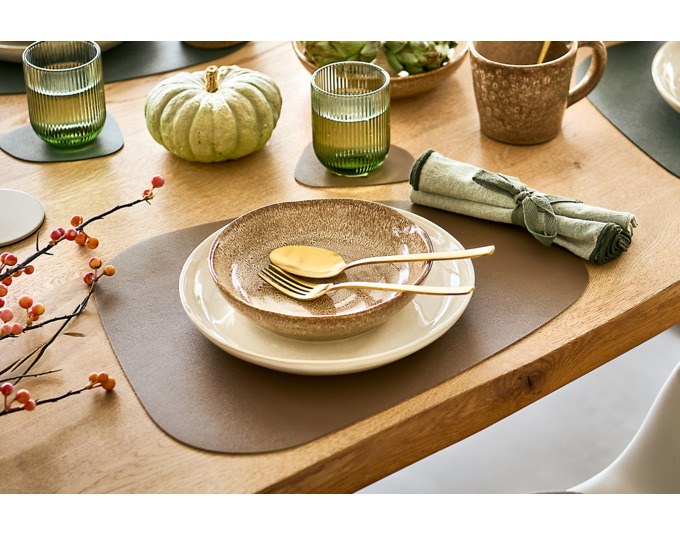Vier runde Glasuntersetzer aus Kunstleder in Beige und Braun, gestapelt auf einer Tischplatte, Produkt von ZELLER PRESENT.