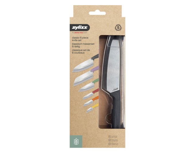 Sechs ZYLISS Küchenmesser mit Edelstahlklingen und farbigen Griffen aus Weizenstrohmaterial, liegend nebeneinander auf heller Fläche.