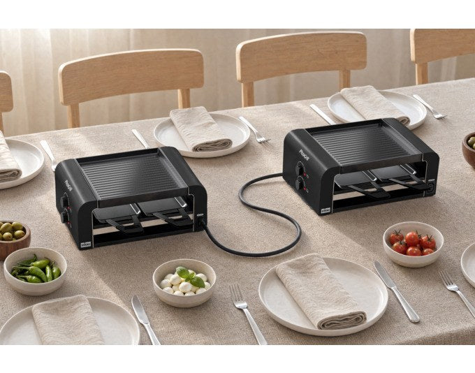Schwarzer STÖCKLI Tischgrill PizzaGrill 4 Connect Set mit Wende-Grillplatte, acht Pfännchen und Kunststoffspachteln auf hellem Hintergrund.