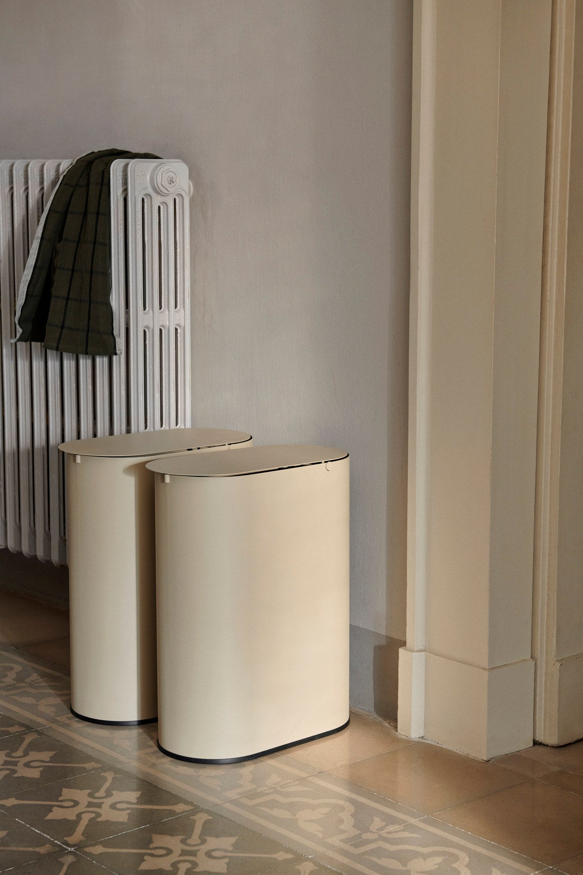 Enkel Behälter von Ferm Living: ovaler Mülleimer aus pulverbeschichtetem Kohlenstoffstahl in dunkler Schokoladenfarbe mit Metallgriff am Innenbehälter.